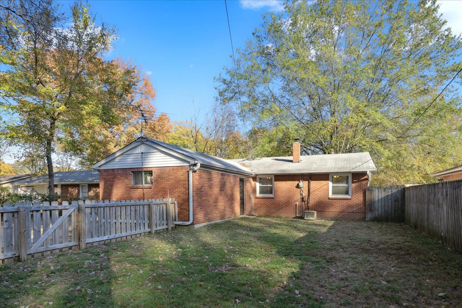 Back of property with a lawn