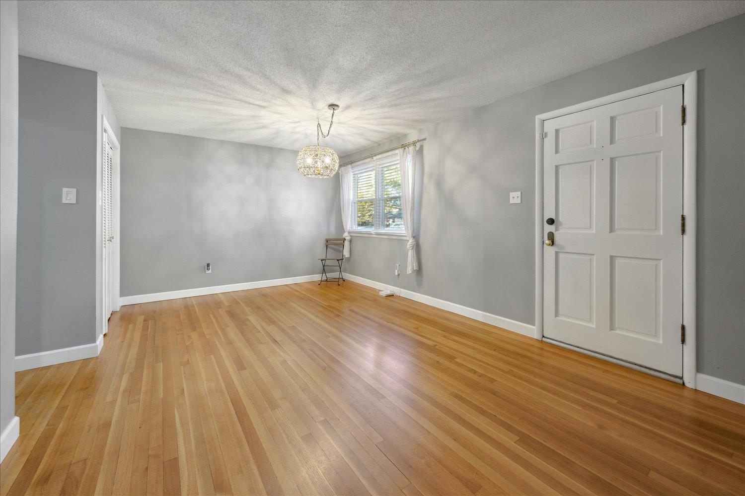 Interior space with a textured ceiling, light hardwood / wood-style floors, and an inviting chandelier