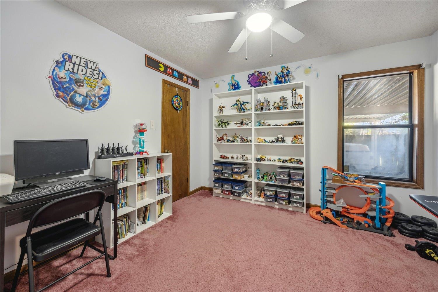 Carpeted office space featuring ceiling fan and a textured ceiling