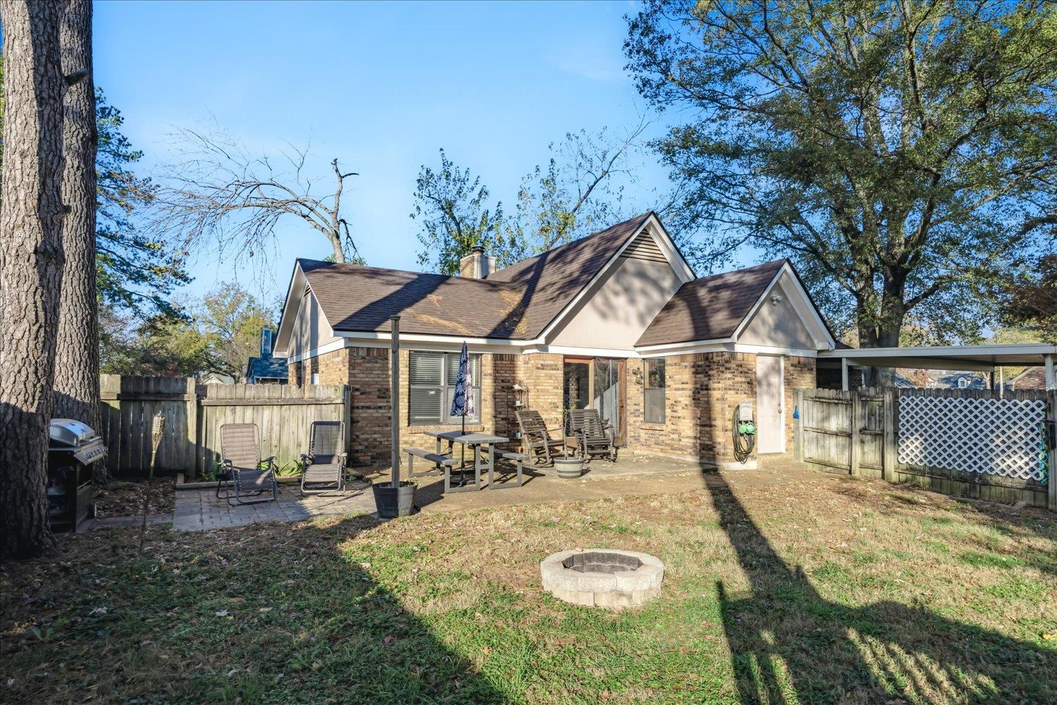 View of front facade with a fire pit, a patio, and a front lawn