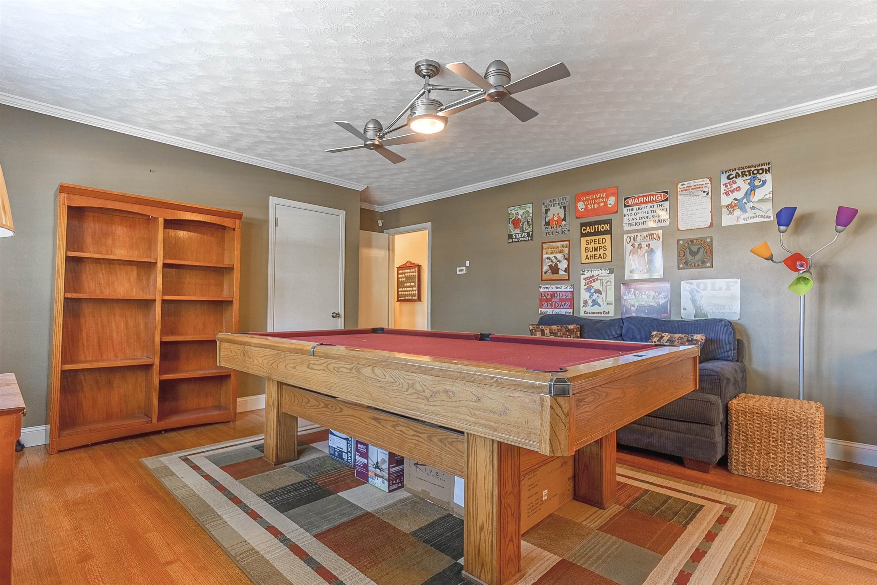 Rec room with hardwood / wood-style floors, ornamental molding, a textured ceiling, and billiards
