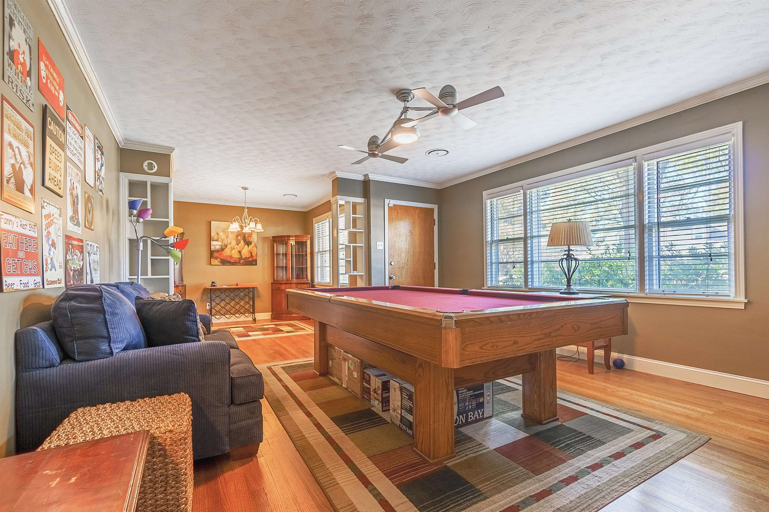 Game room featuring wood-type flooring, a textured ceiling, crown molding, and billiards