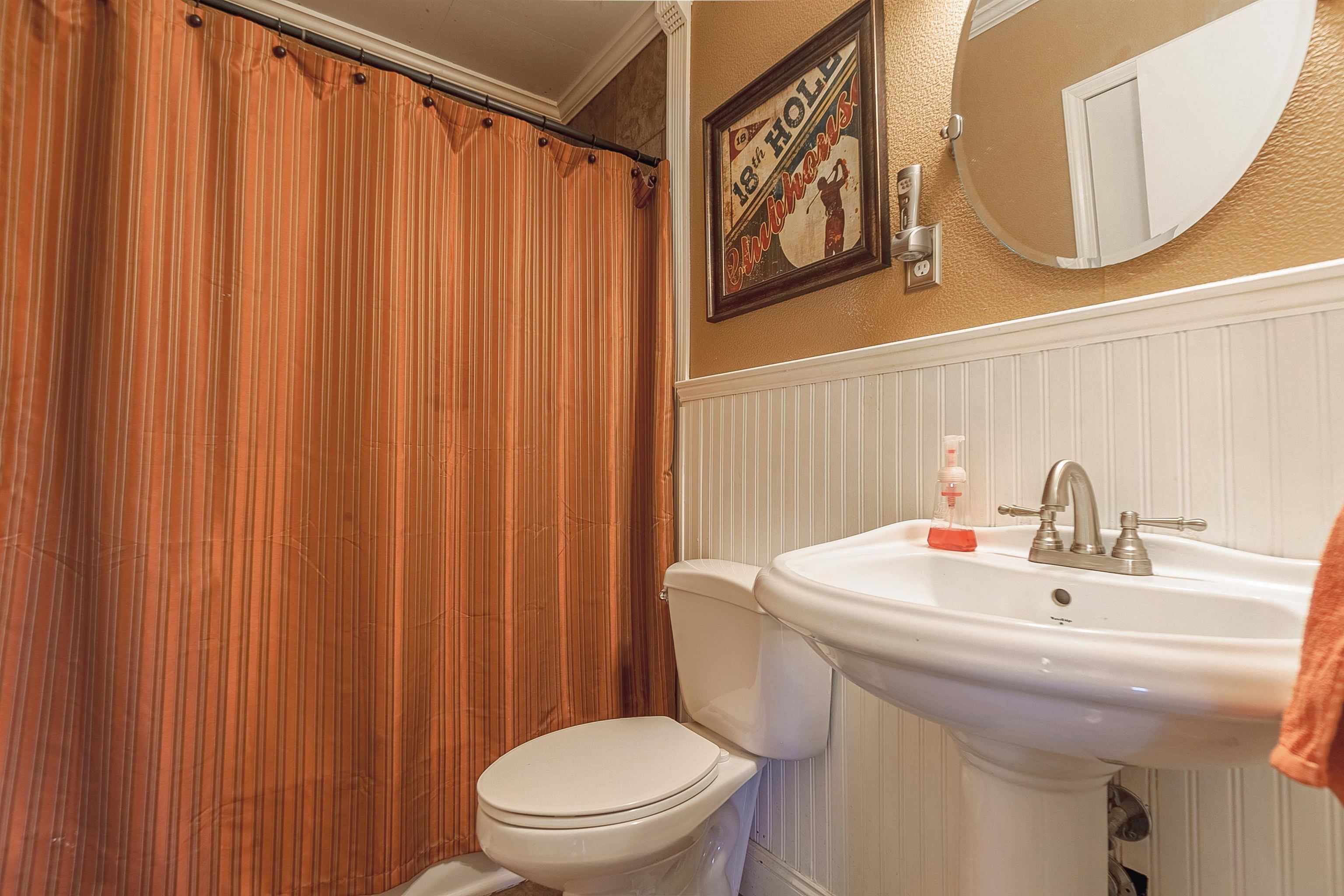 Bathroom with toilet, walk in shower, and crown molding