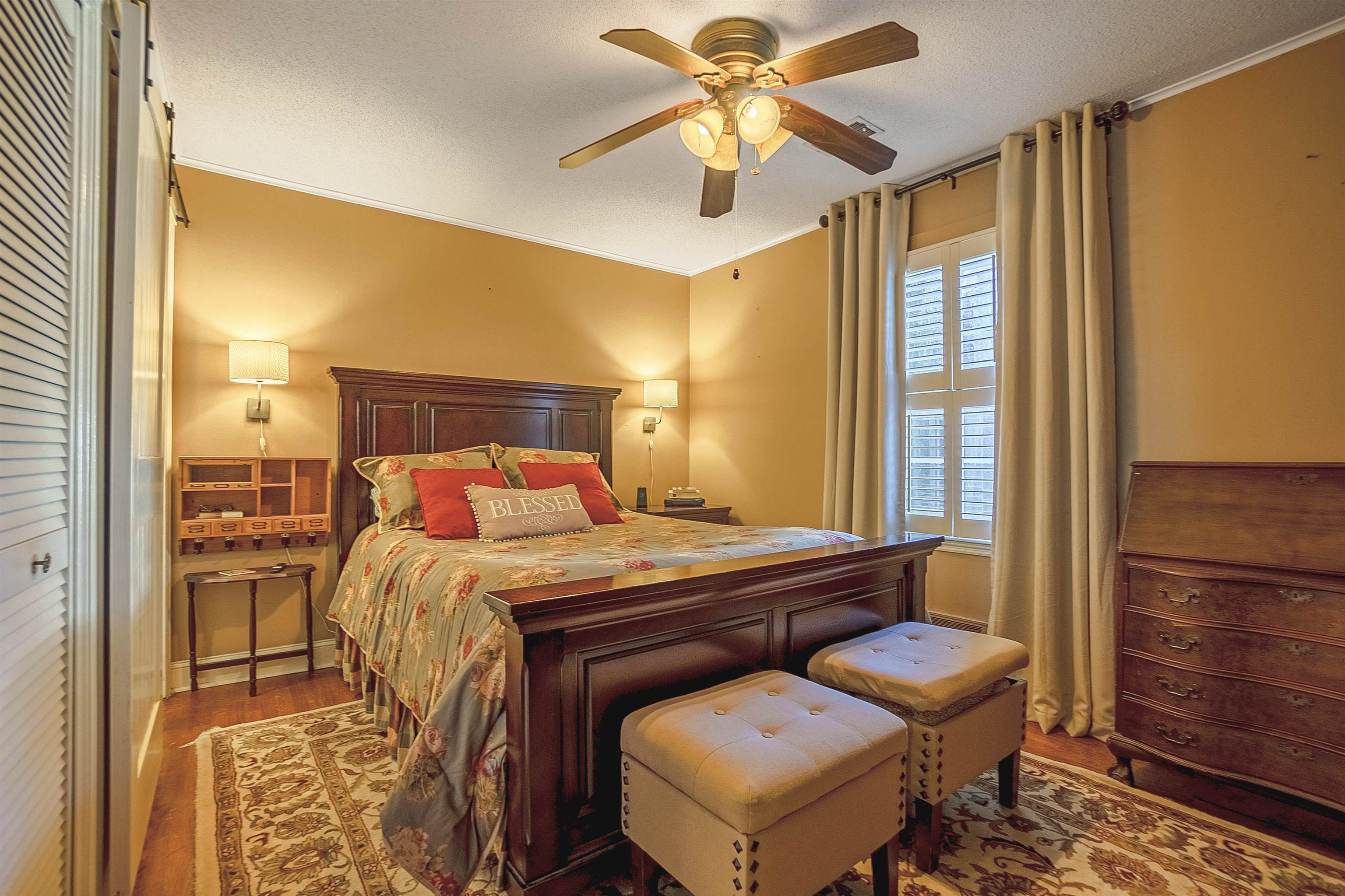Bedroom with ceiling fan, ornamental molding, a textured ceiling, and hardwood / wood-style flooring