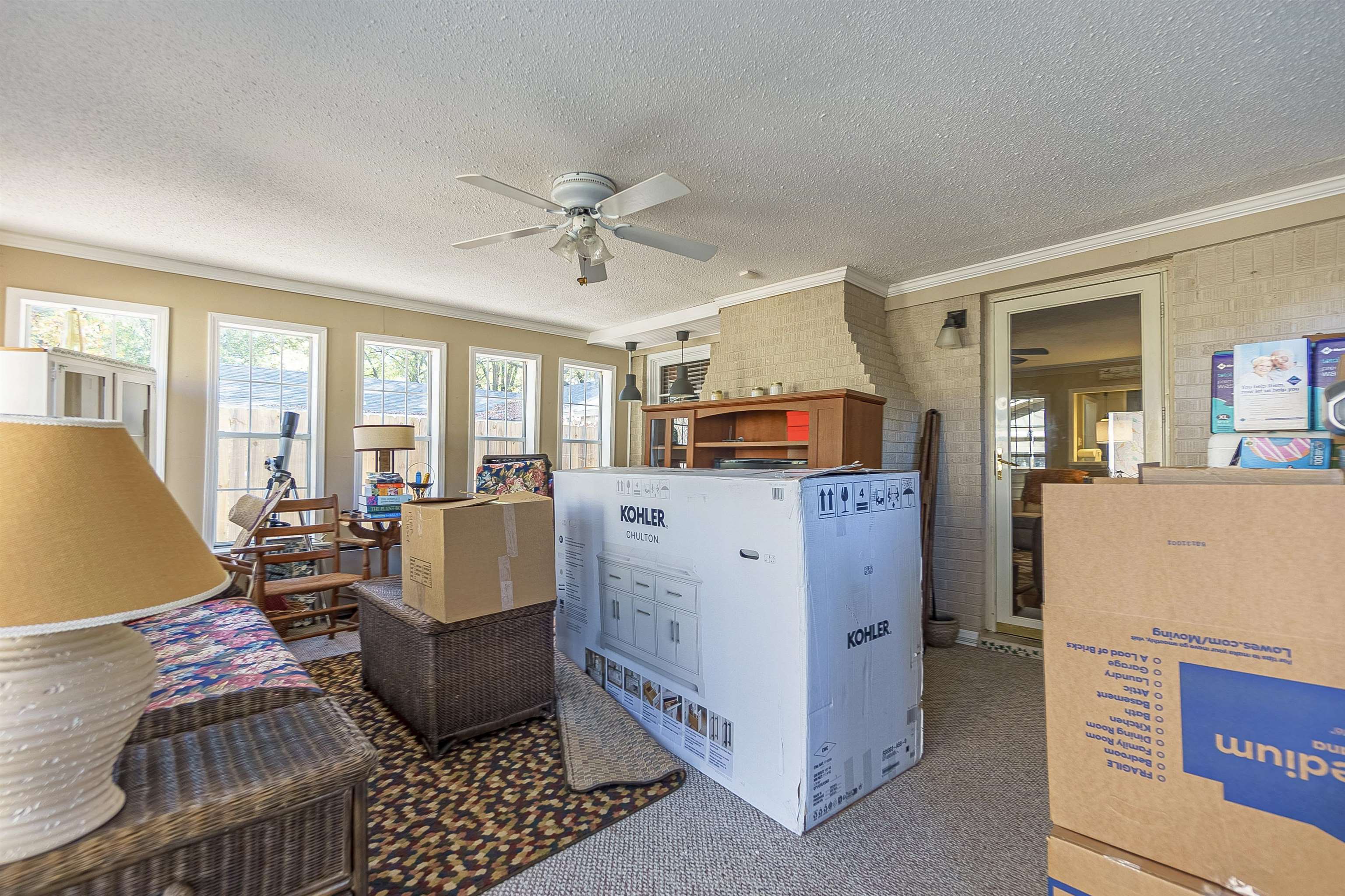 Interior space with carpet flooring, ceiling fan, a textured ceiling, and ornamental molding