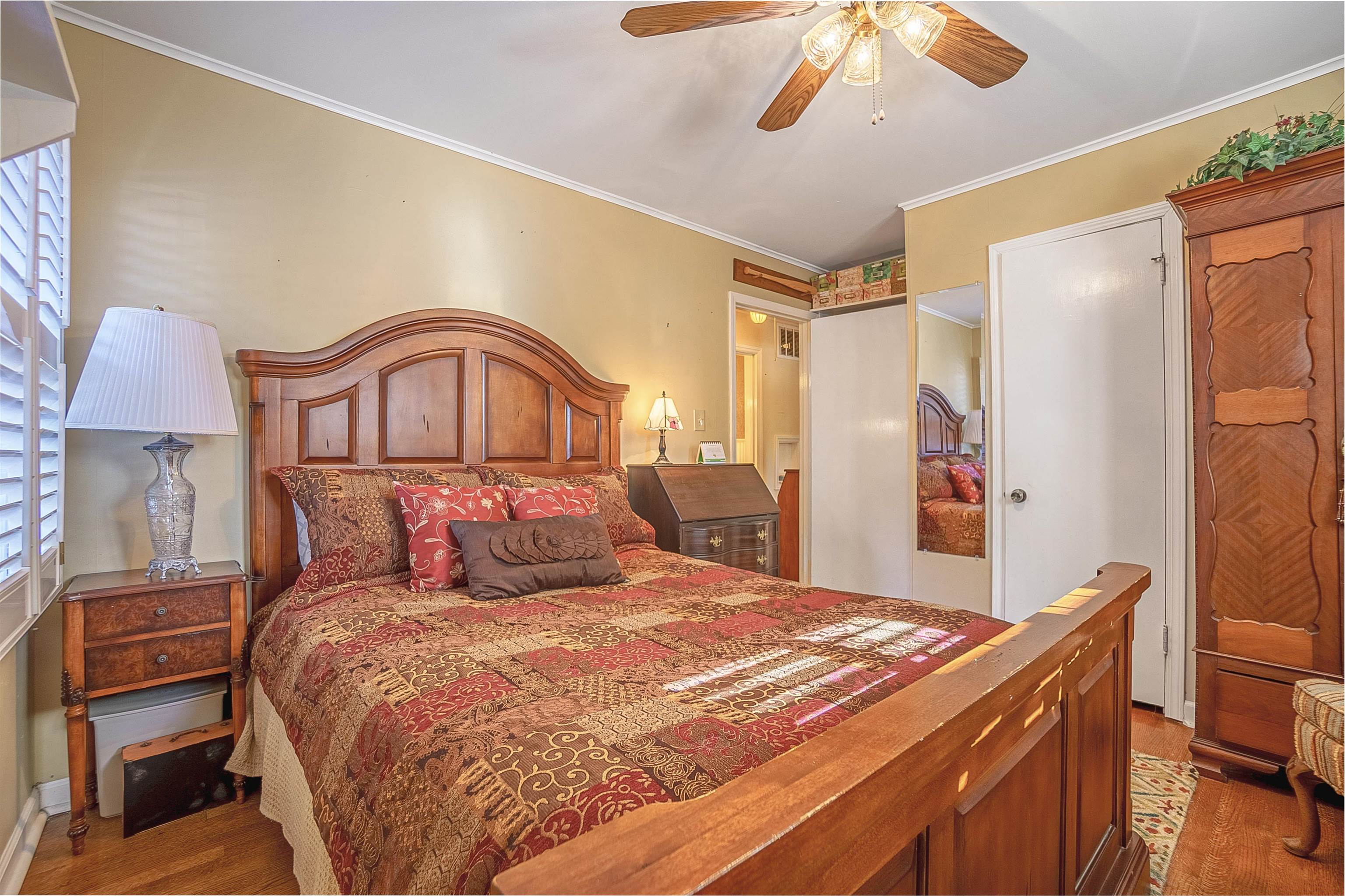 Bedroom featuring ceiling fan, wood-type flooring, and crown molding