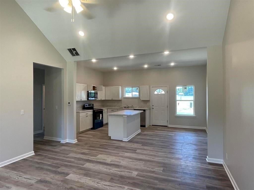 Kitchen with white cabinetry, electric range, a center island, and light wood-type flooring