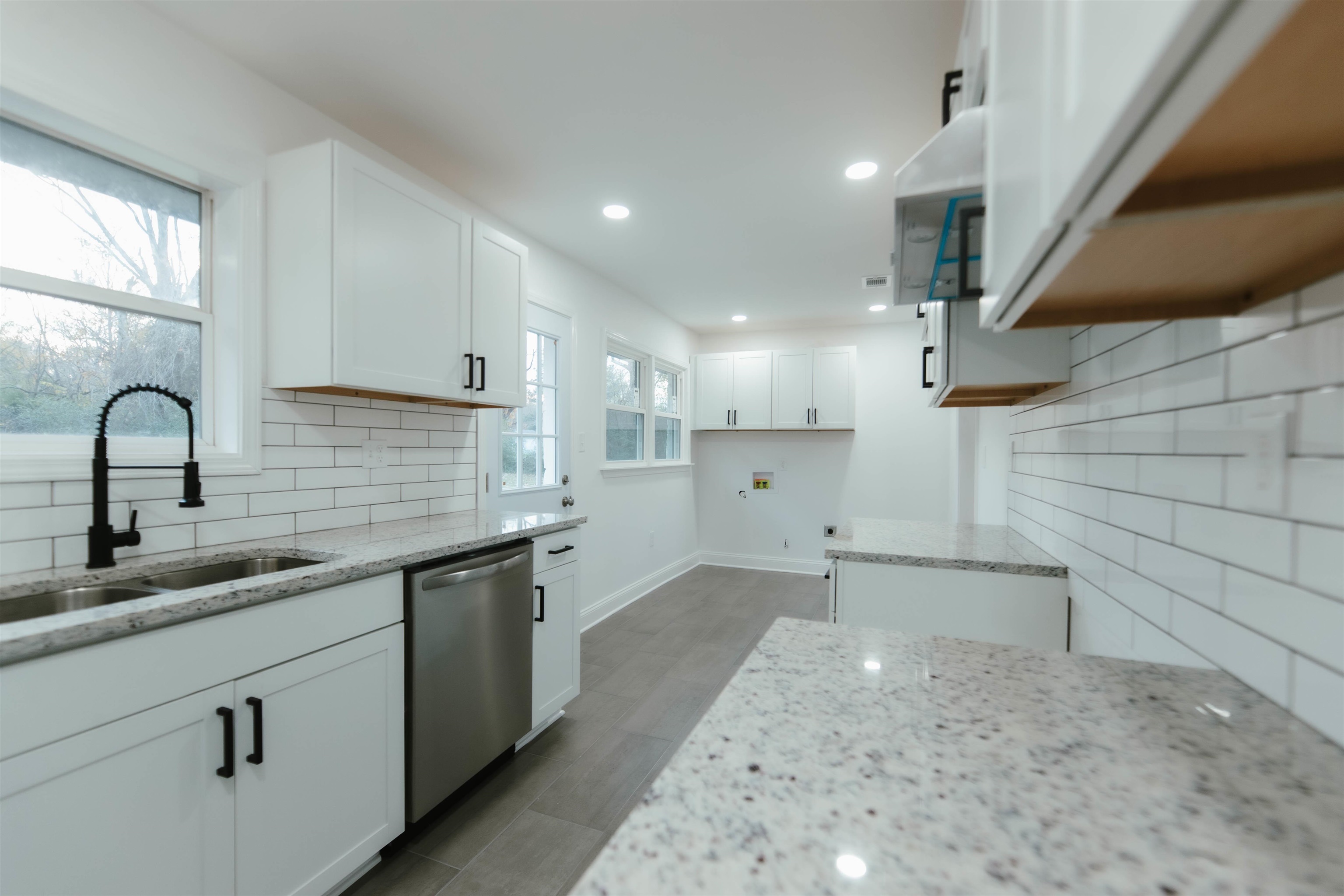 Kitchen featuring dishwasher, white cabinets, a healthy amount of sunlight, and sink