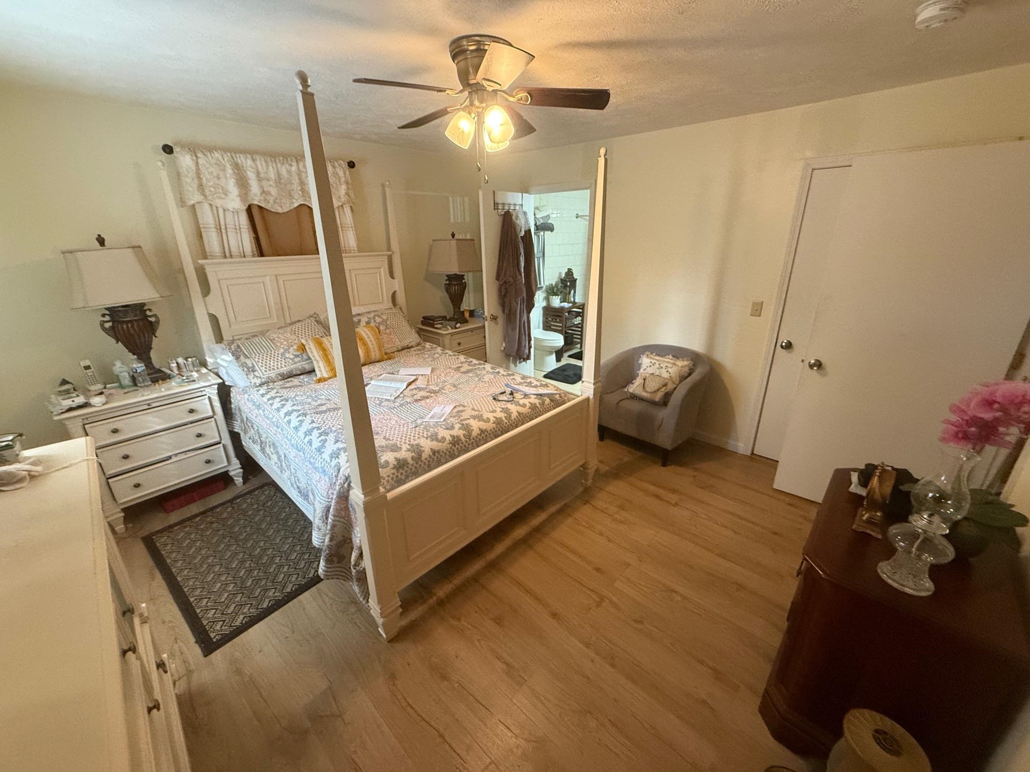 Bedroom with a closet, ceiling fan, a textured ceiling, and light hardwood / wood-style floors