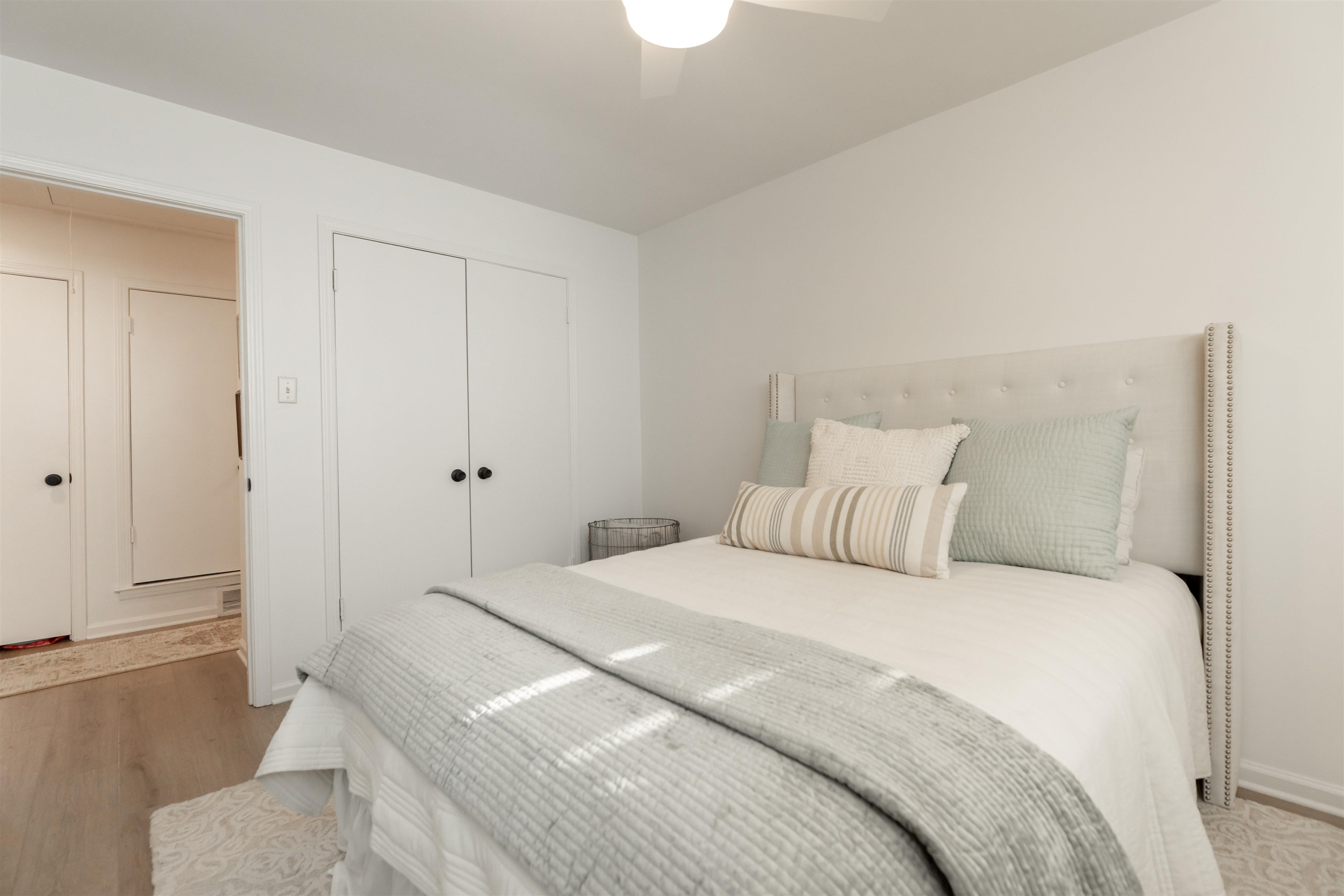 Bedroom with a closet, light hardwood / wood-style floors, and ceiling fan