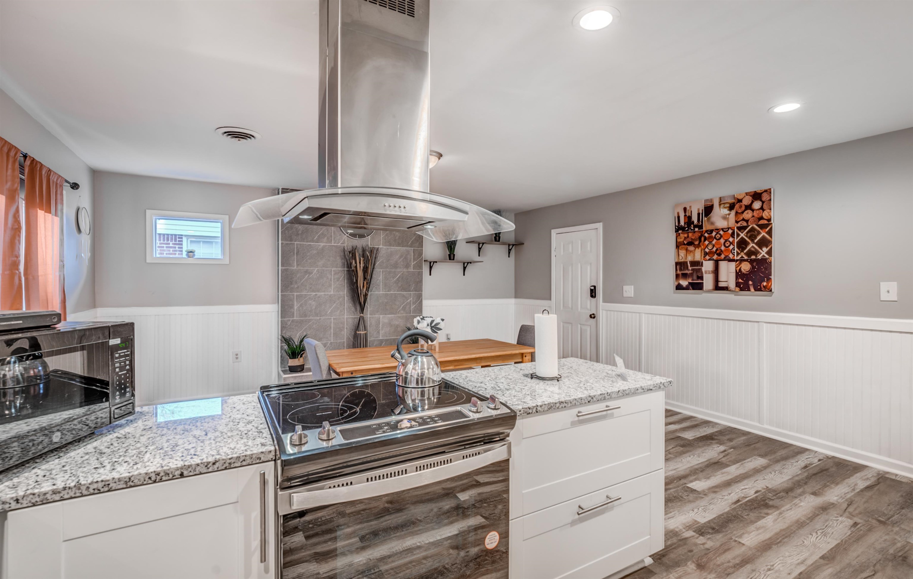Kitchen with light hardwood / wood-style floors, white cabinetry, extractor fan, and electric stove