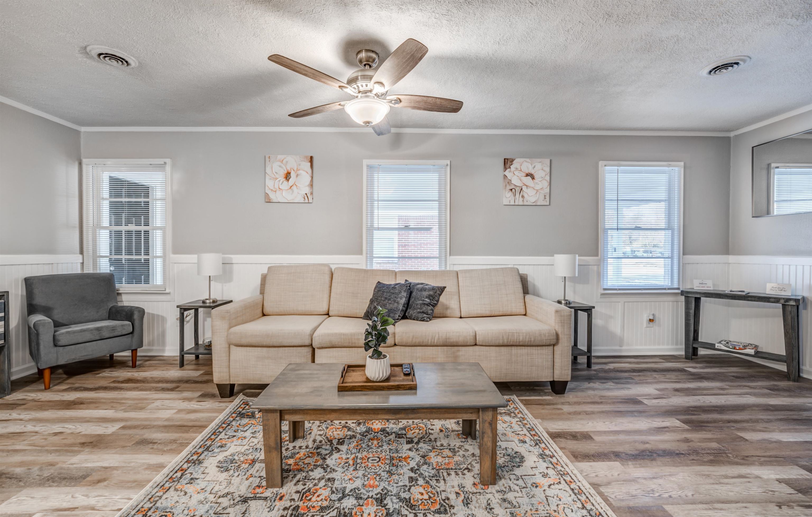 Living room featuring a textured ceiling, hardwood / wood-style flooring, and crown molding