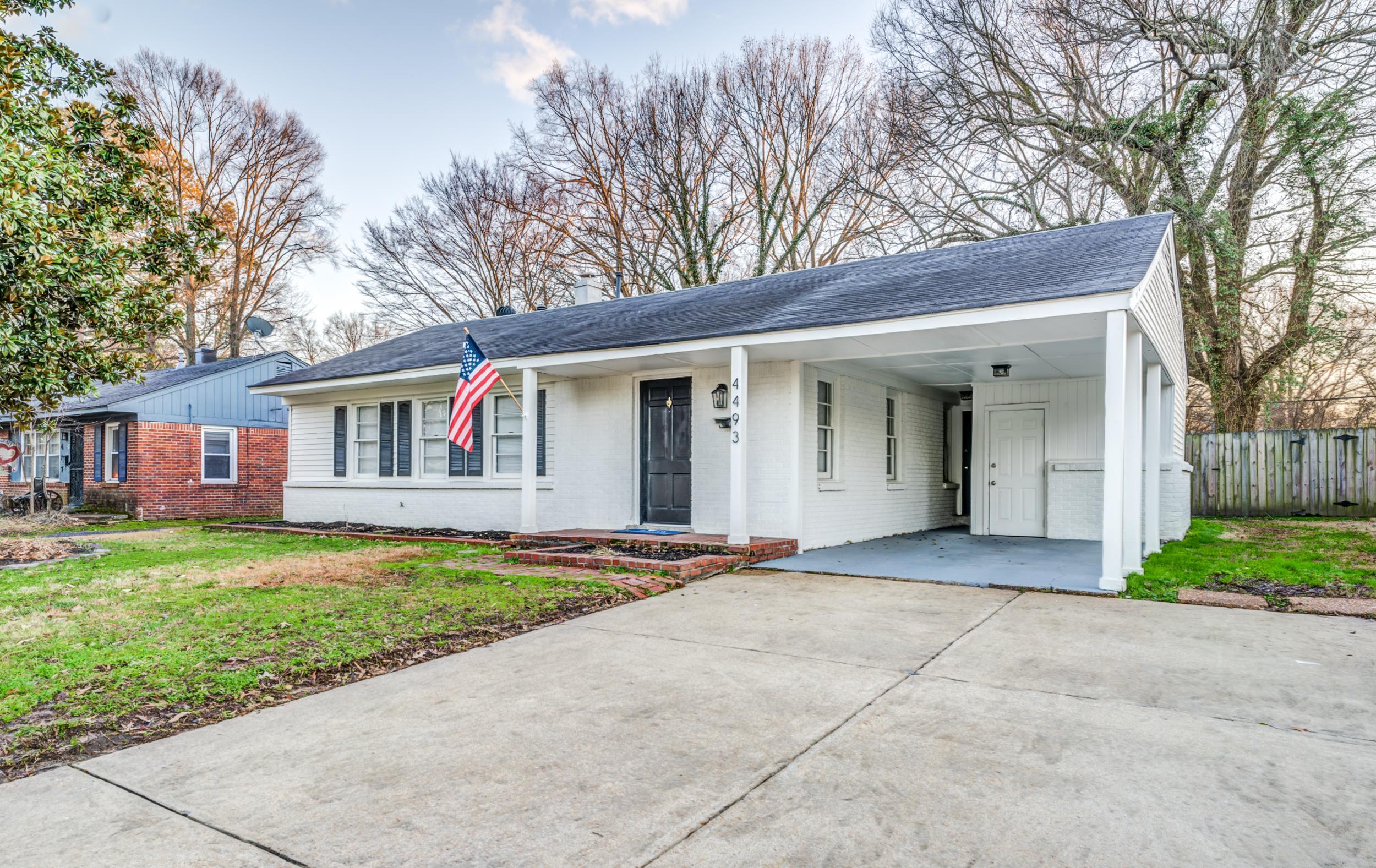 Ranch-style house with a carport and a front yard