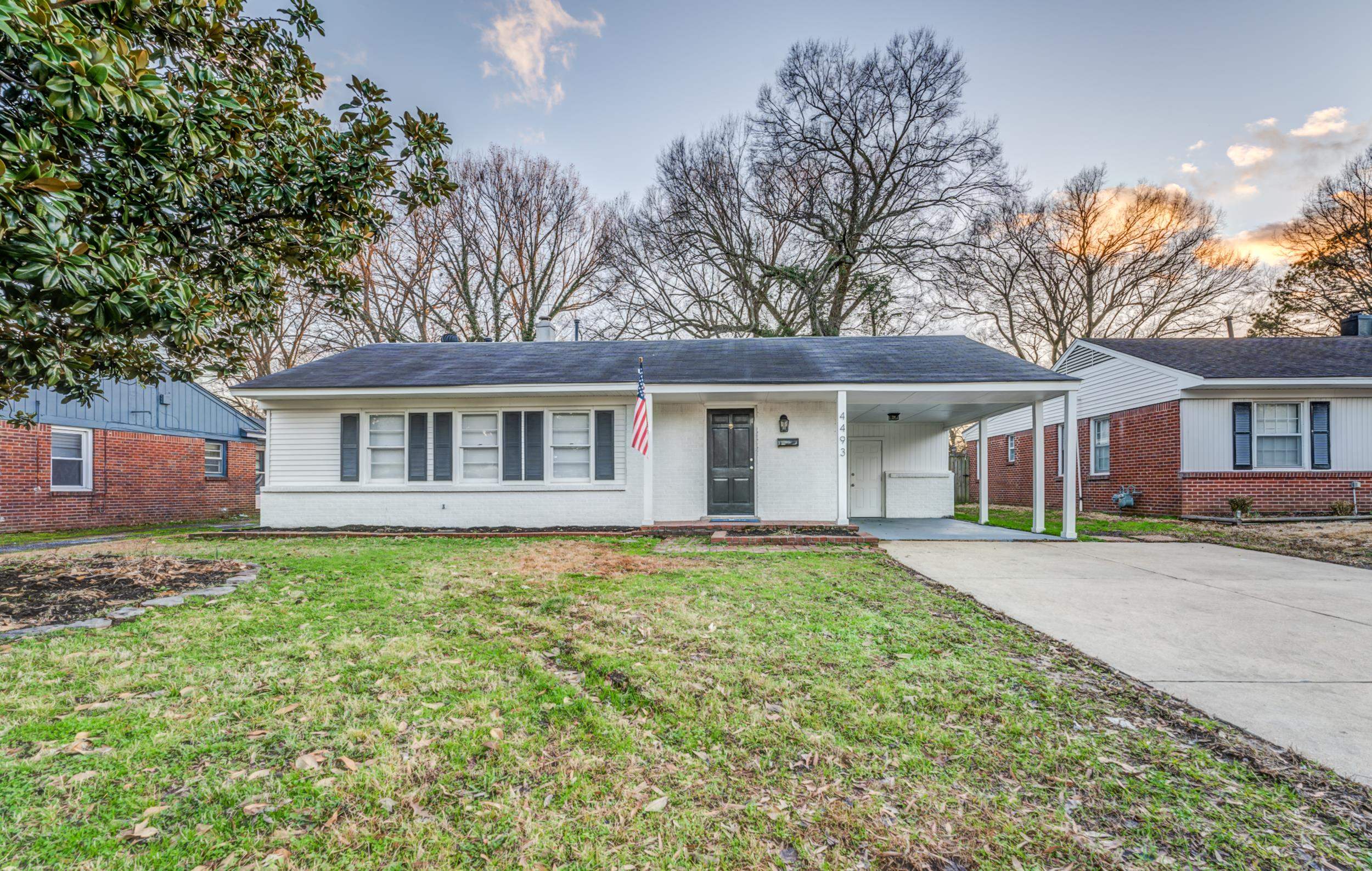 Single story home with a yard and a carport