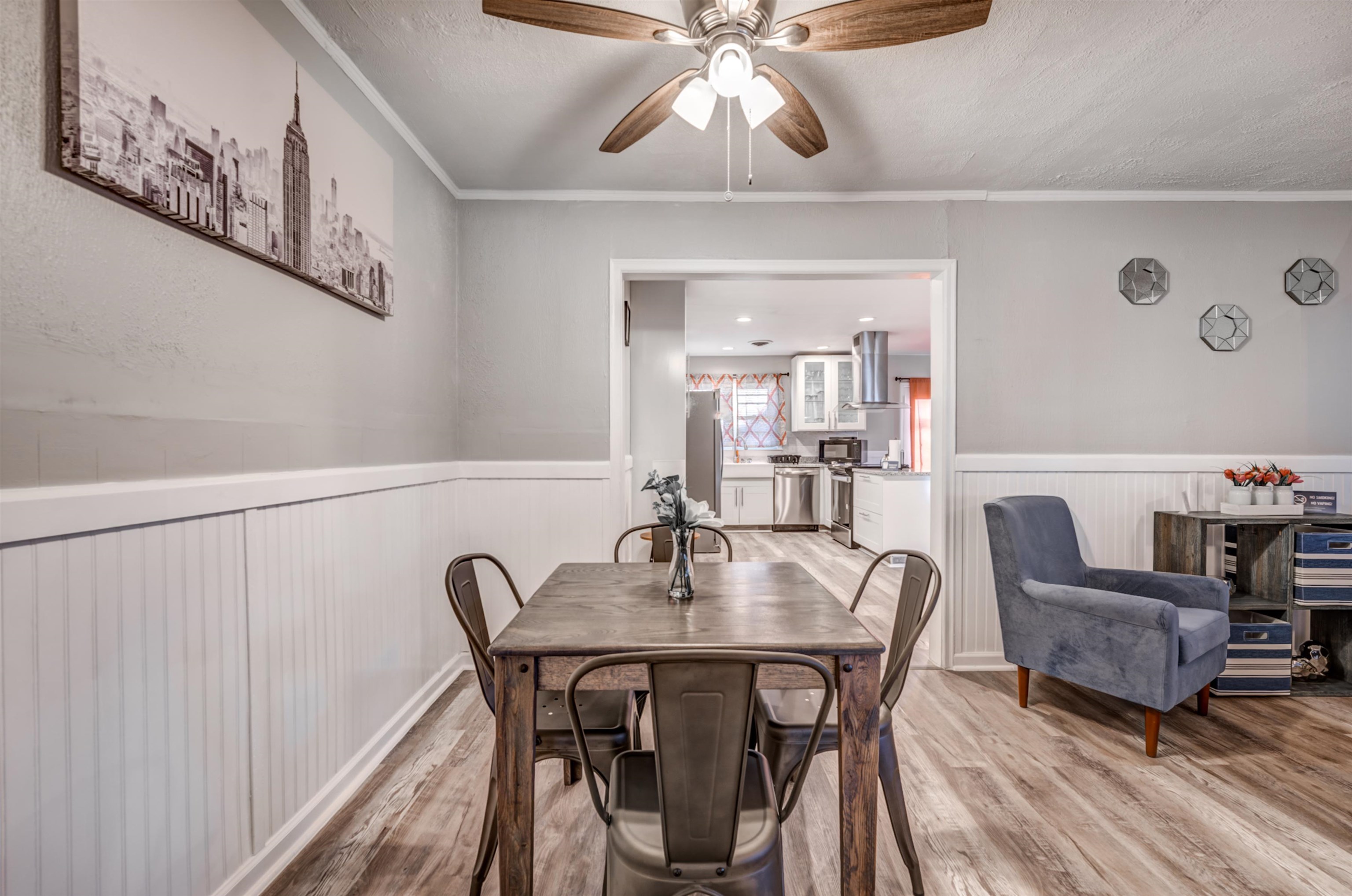 Dining room with ceiling fan, light hardwood / wood-style floors, a textured ceiling, and ornamental molding
