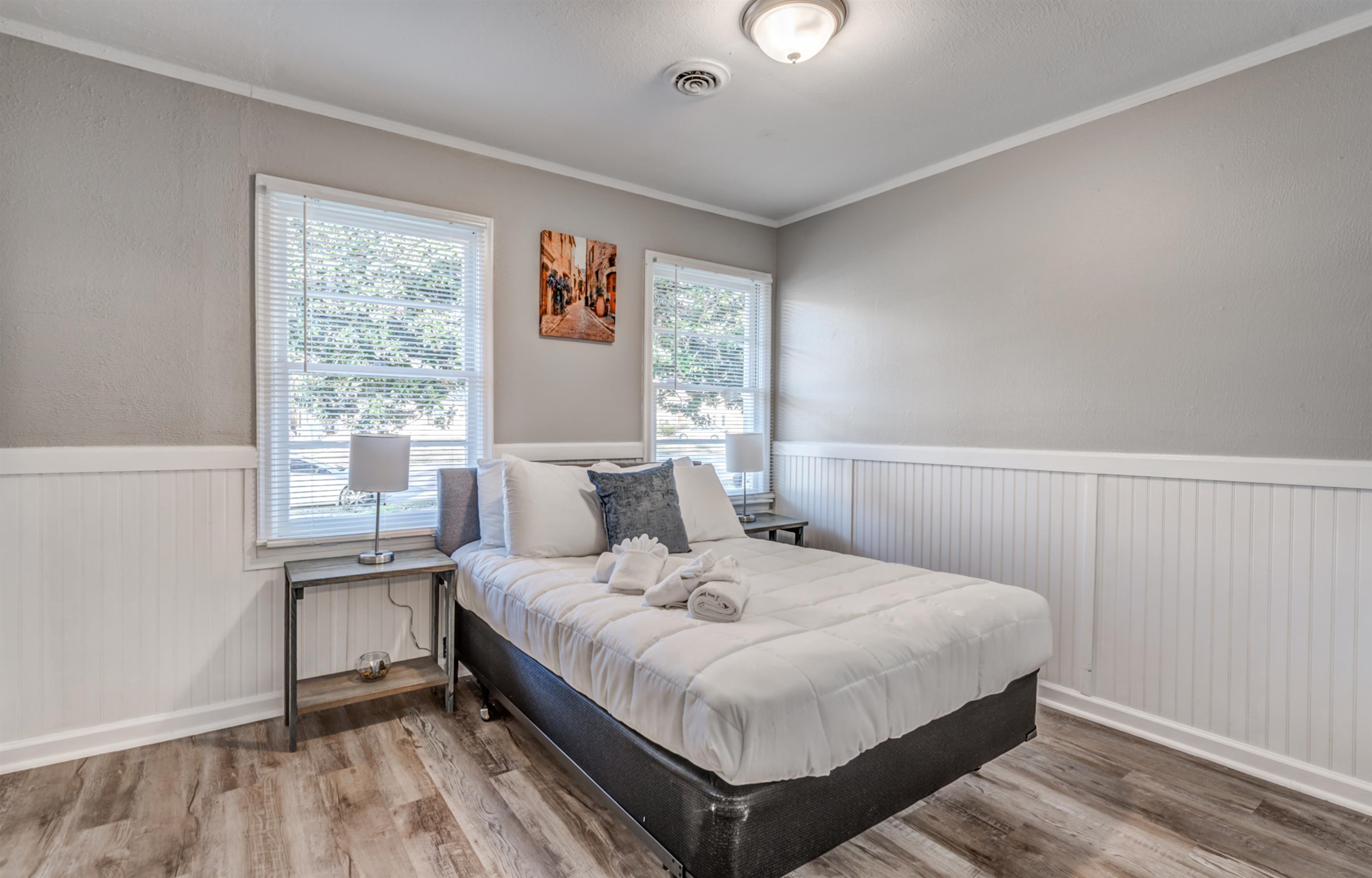 Bedroom with hardwood / wood-style flooring, multiple windows, and crown molding