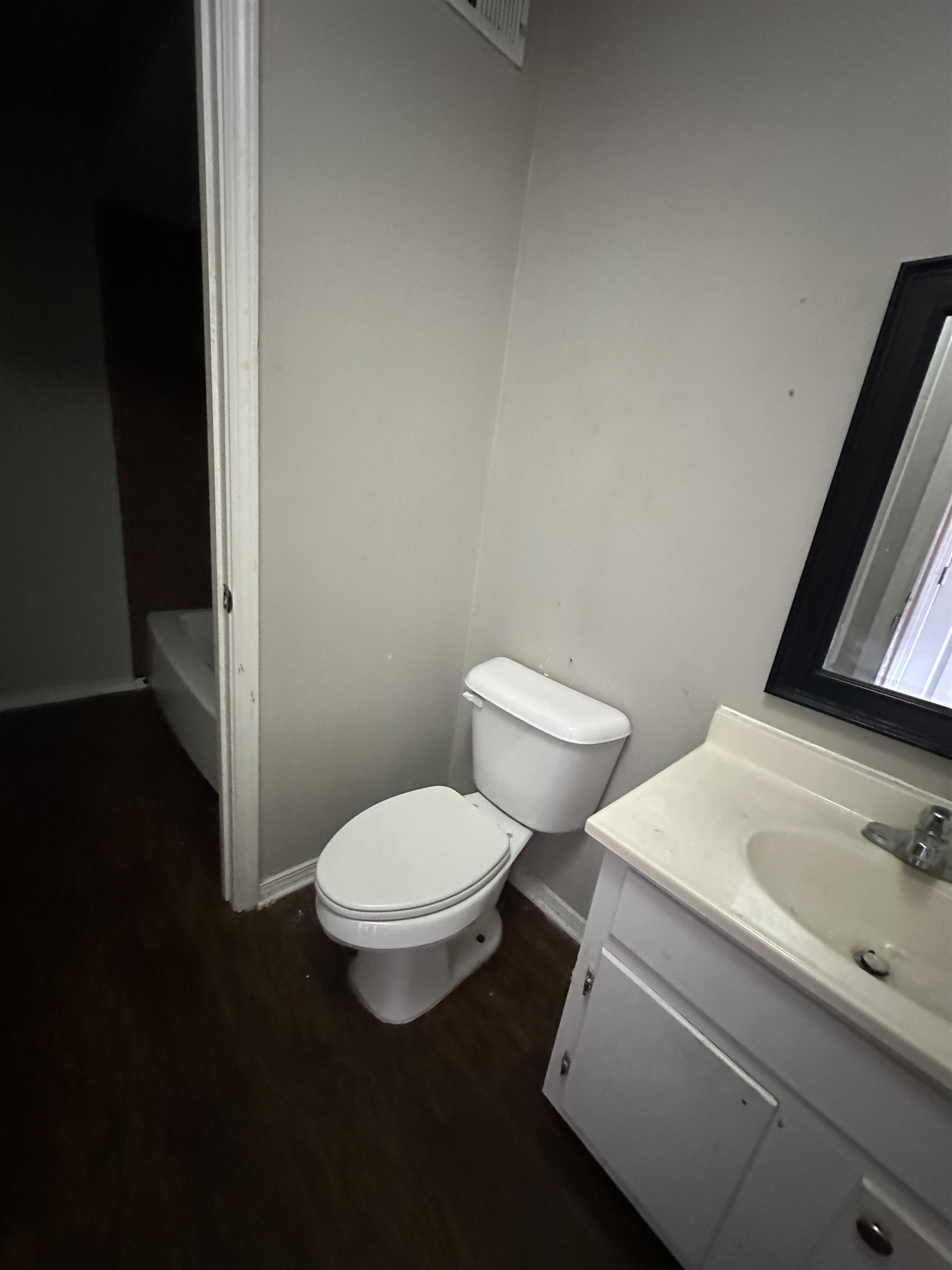 Bathroom with toilet, vanity, and hardwood / wood-style flooring