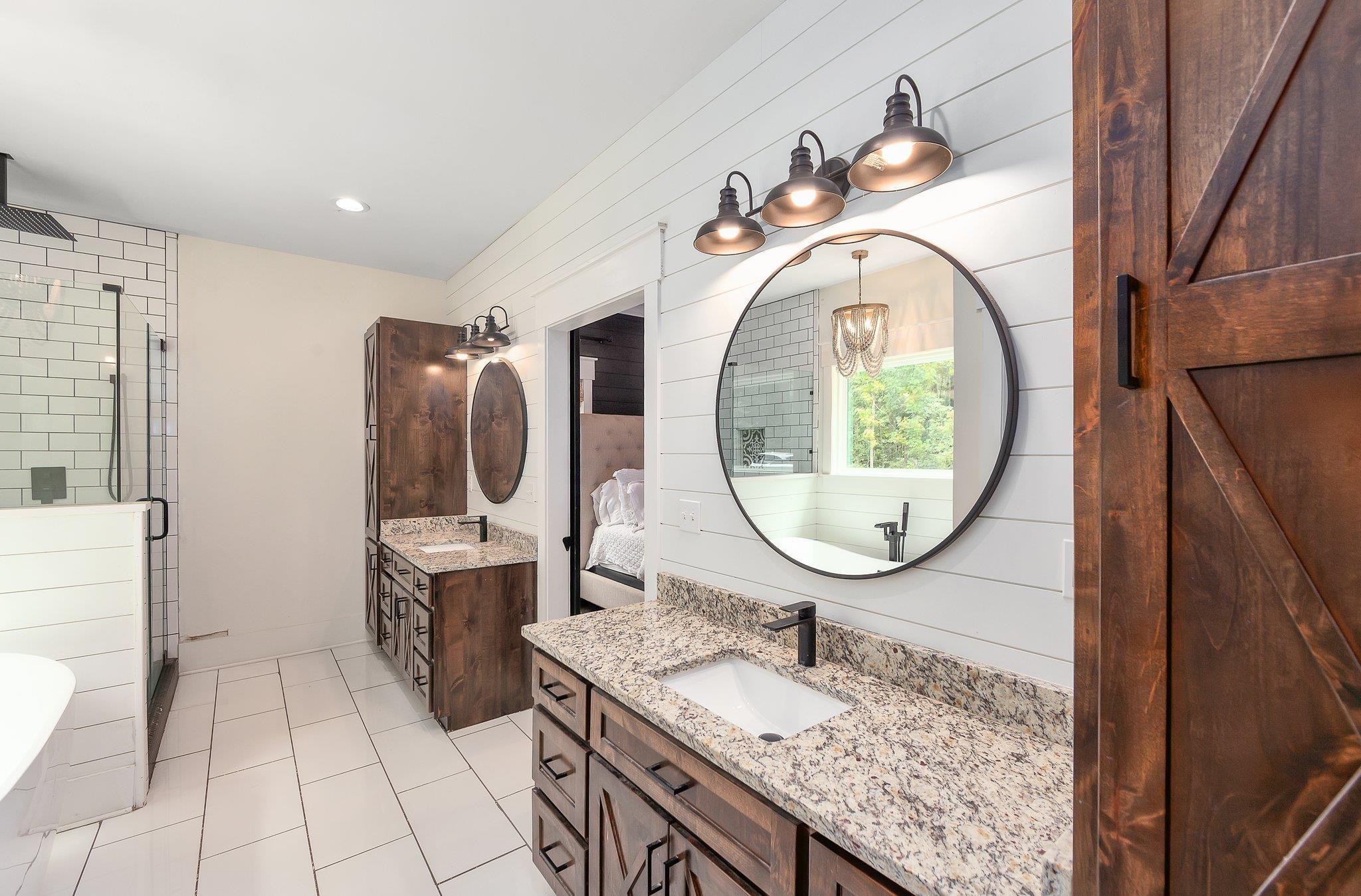 Bathroom with tile patterned floors, vanity, separate shower and tub, and wood walls