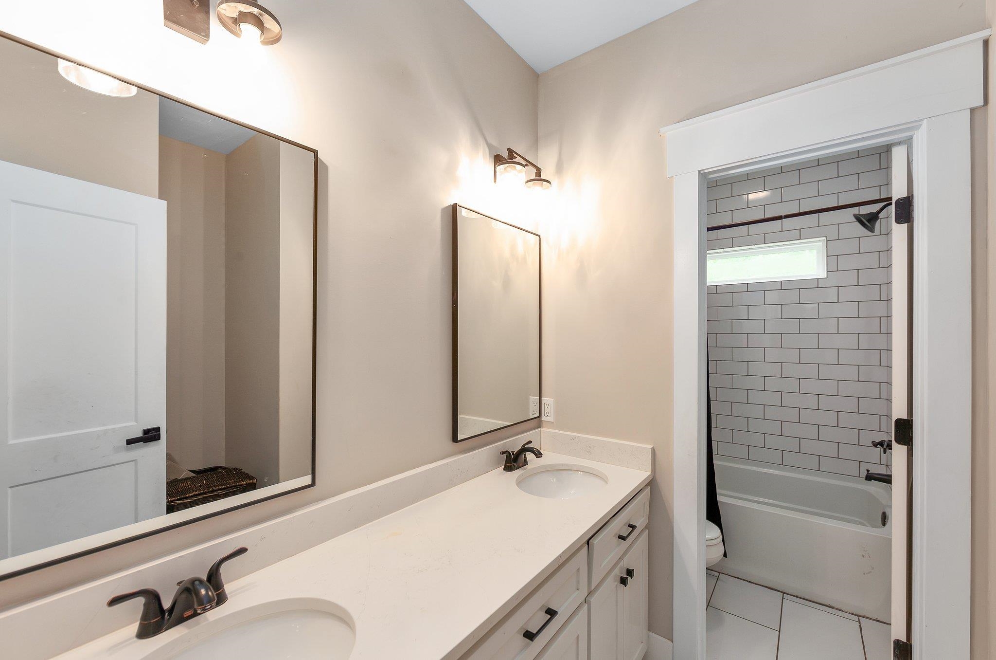 Full bathroom featuring toilet, tile patterned flooring, vanity, and tiled shower / bath