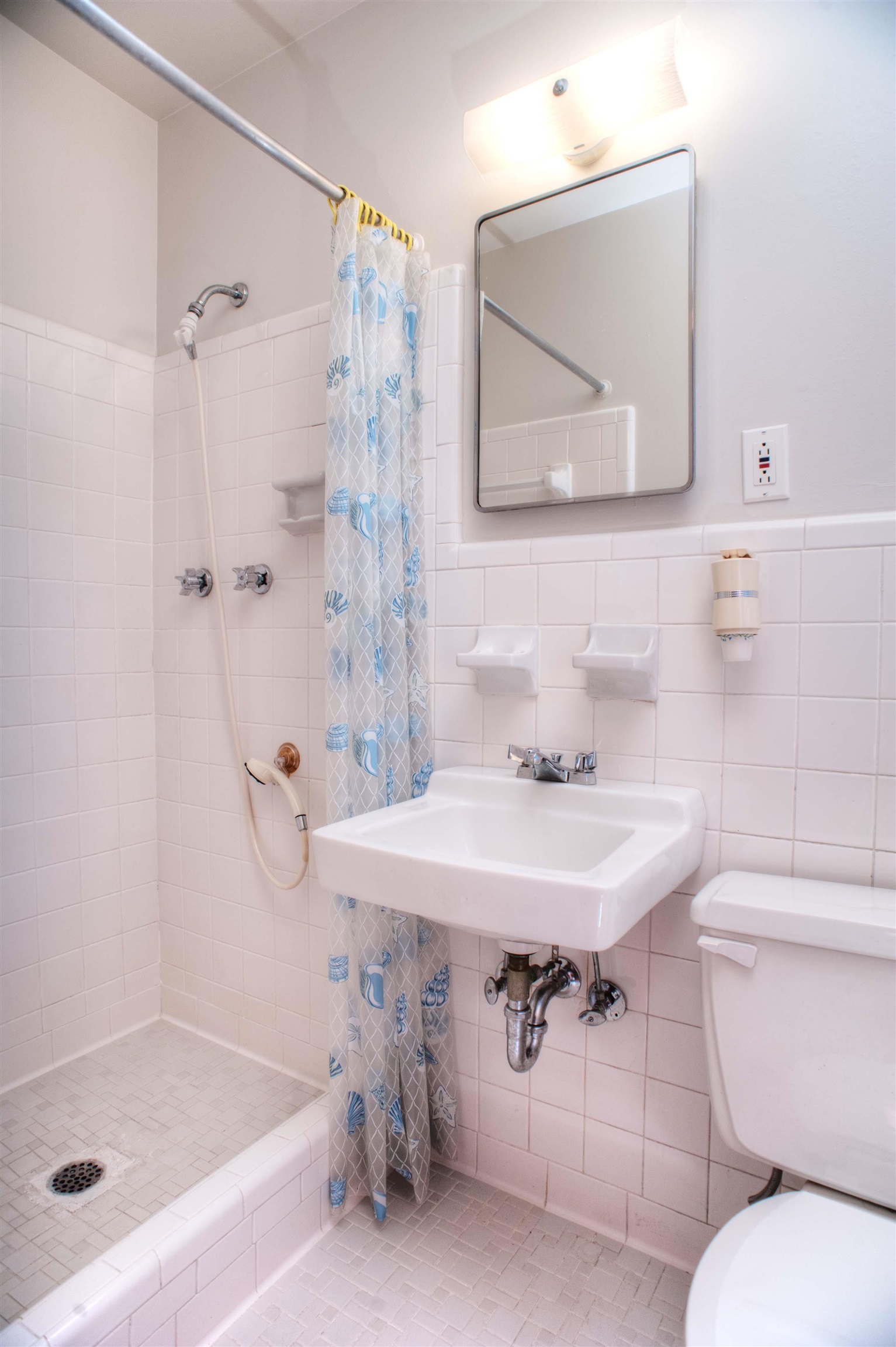 Bathroom featuring tile patterned flooring, toilet, walk in shower, and tile walls