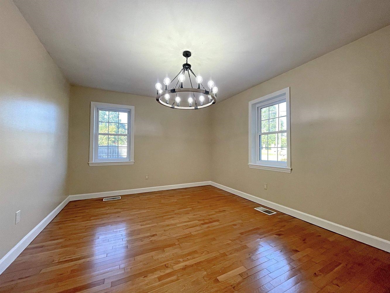 Empty room featuring light hardwood / wood-style floors and a chandelier