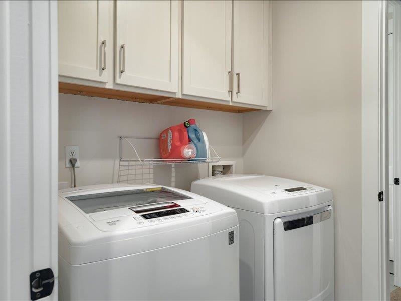 Washroom with cabinets and separate washer and dryer