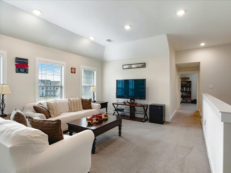 Living room featuring light carpet and vaulted ceiling