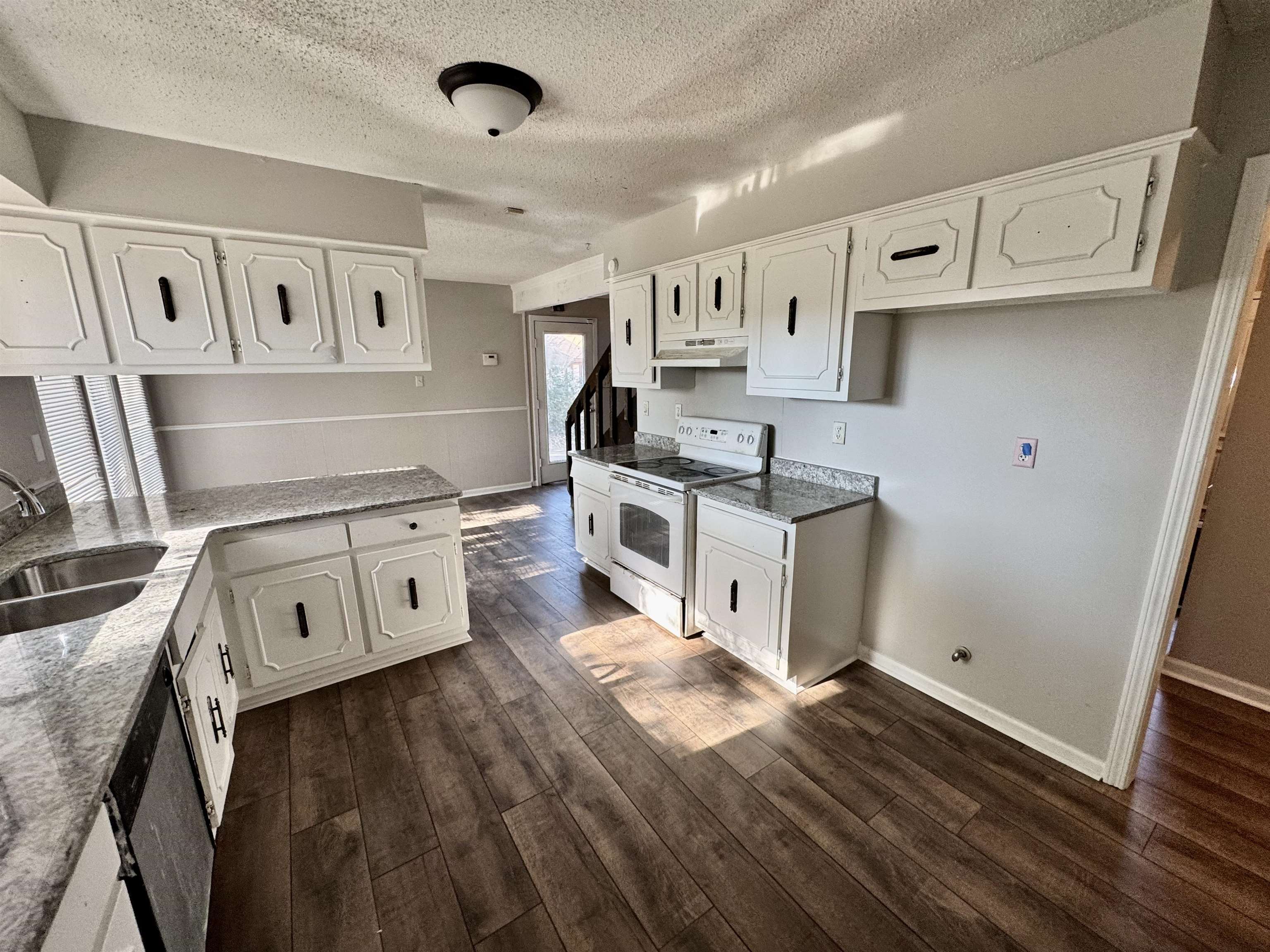 Kitchen with white range with electric cooktop, dark hardwood / wood-style flooring, white cabinets, and sink