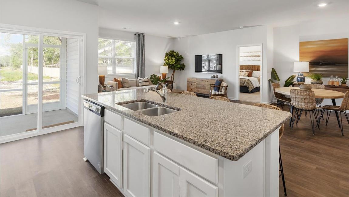 Kitchen featuring white cabinetry, dark wood-type flooring, sink, and an island with sink