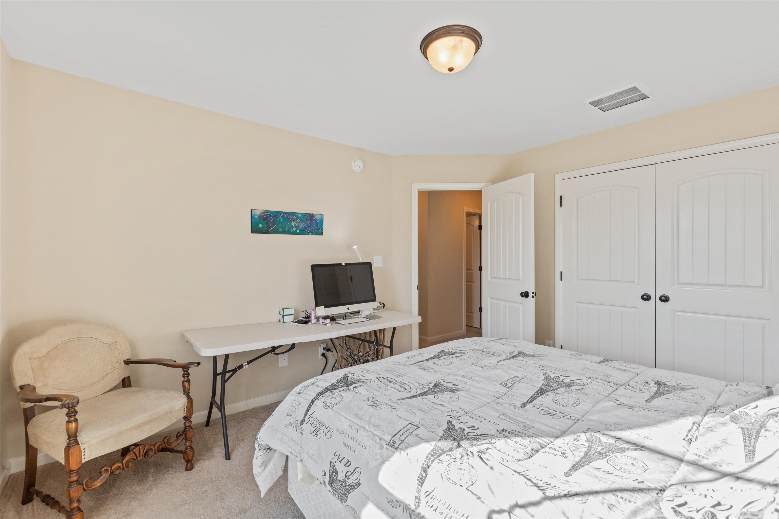 Bedroom featuring light colored carpet and a closet