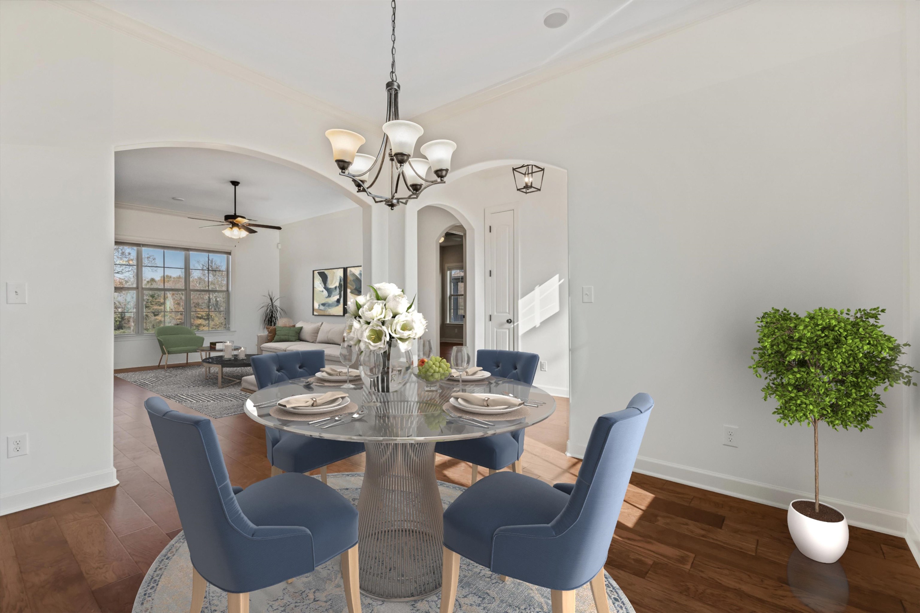 Dining space featuring crown molding, dark wood-type flooring, and ceiling fan with notable chandelier