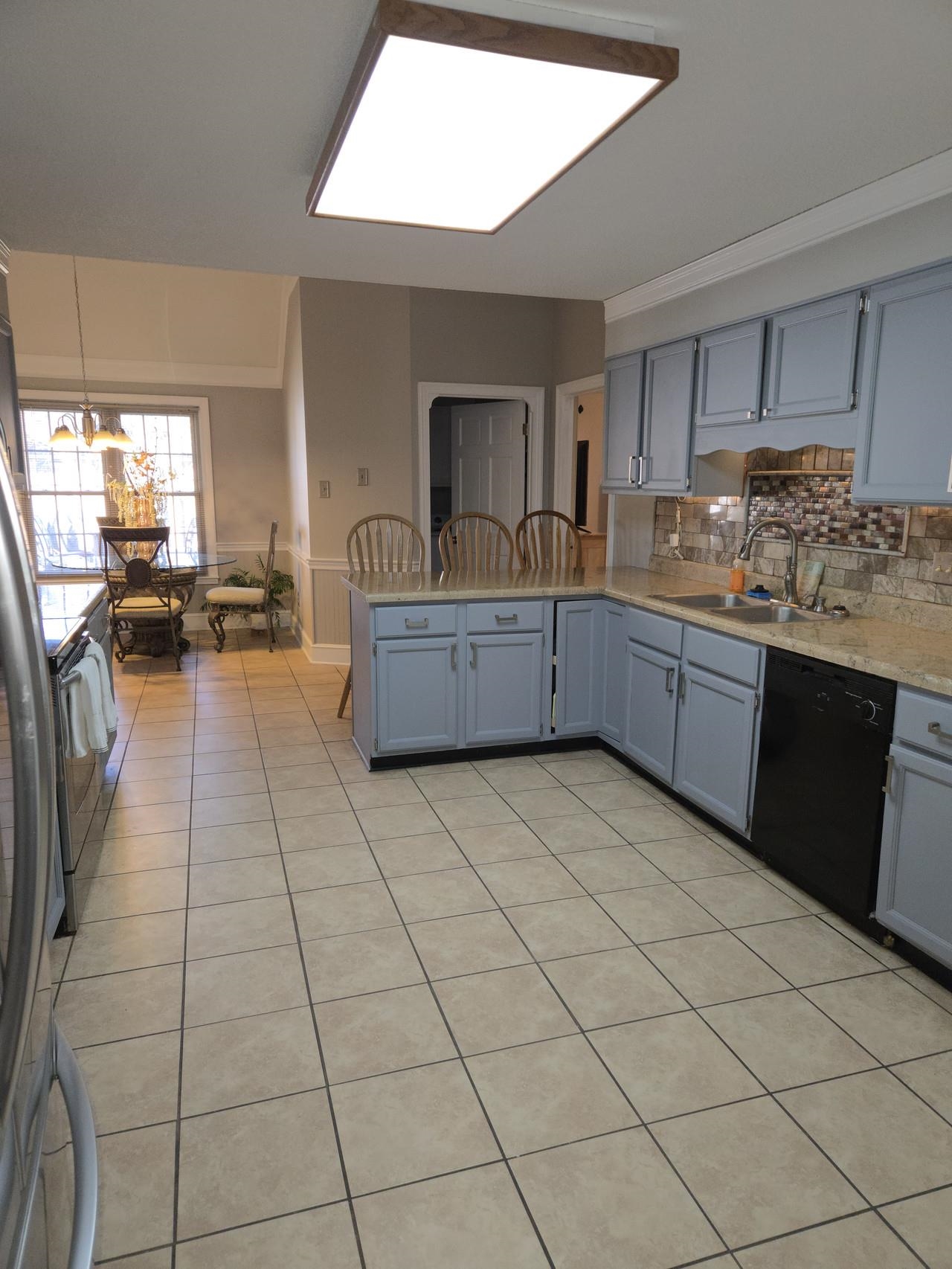 Kitchen featuring dishwasher, sink, kitchen peninsula, crown molding, and decorative light fixtures