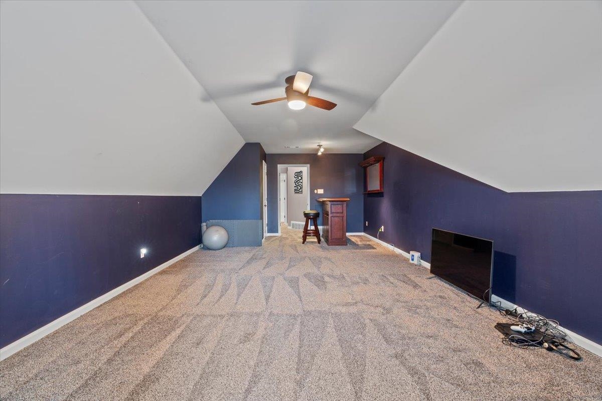 Bonus room featuring carpet, vaulted ceiling, and ceiling fan