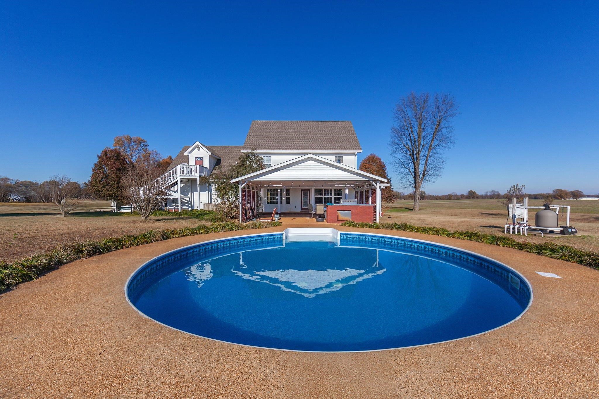 View of swimming pool featuring covered porch and a yard