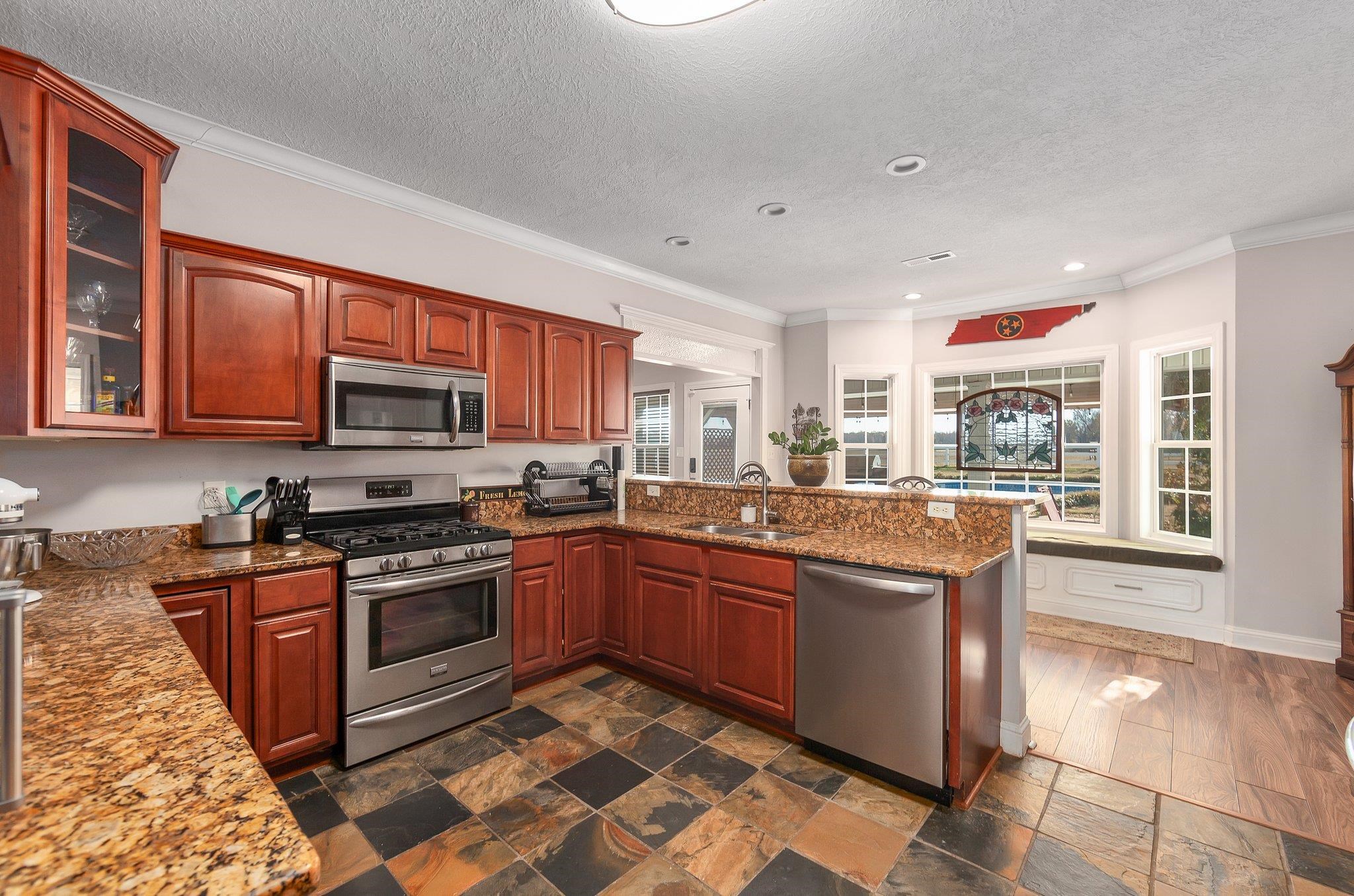 Kitchen featuring kitchen peninsula, a healthy amount of sunlight, sink, and stainless steel appliances