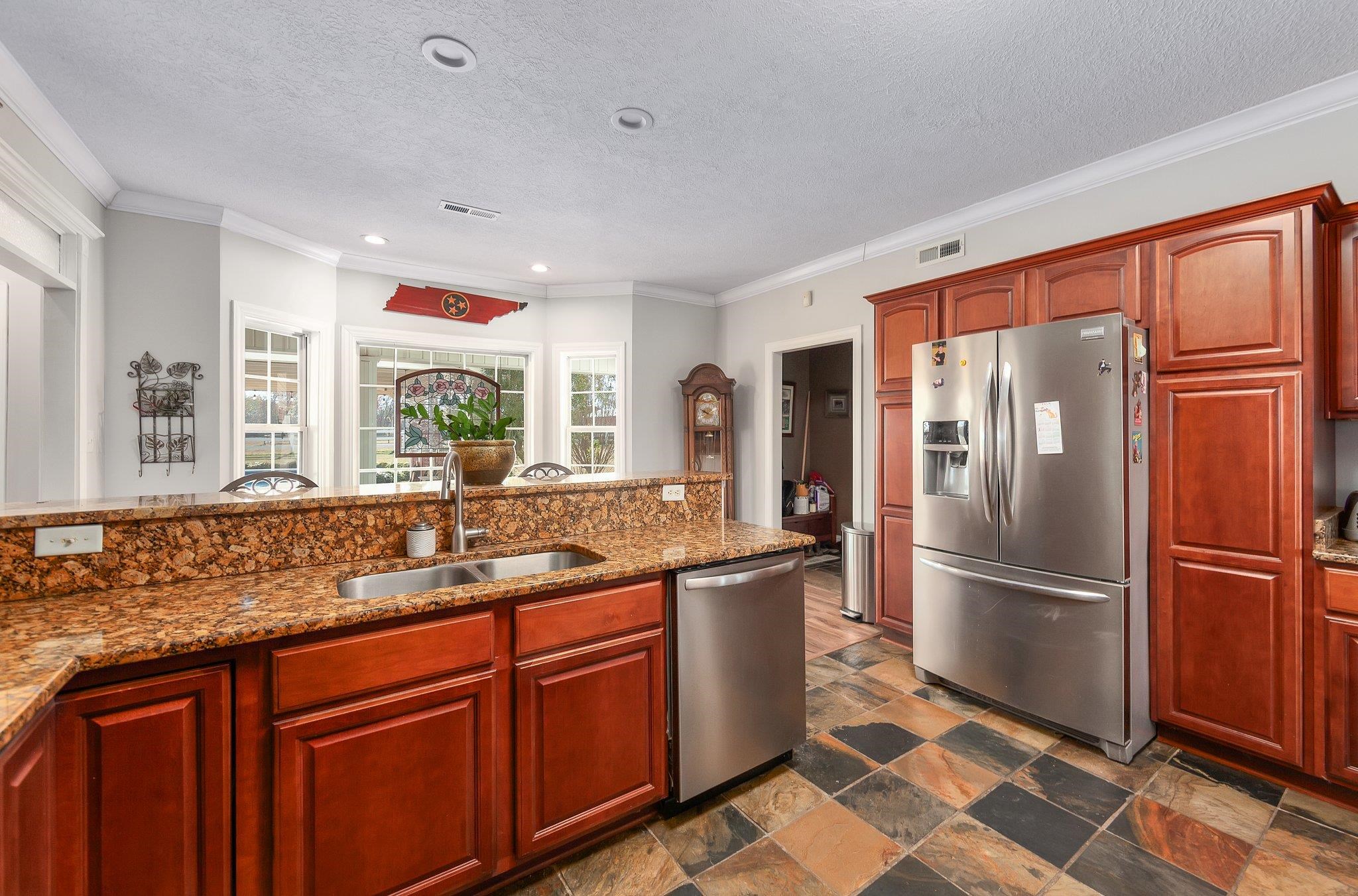 Kitchen featuring crown molding, sink, light stone countertops, a textured ceiling, and stainless steel appliances