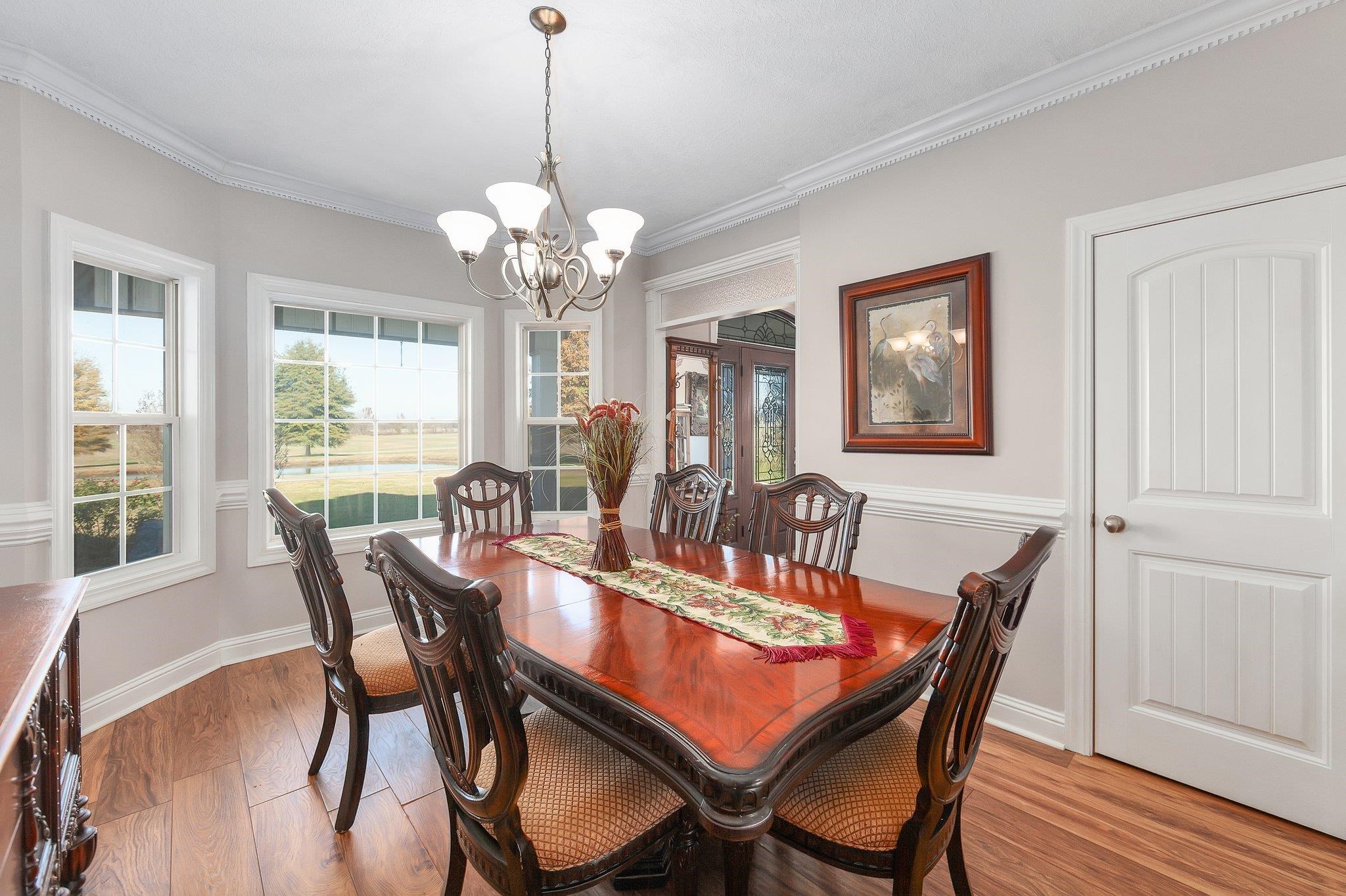 Dining space featuring an inviting chandelier, ornamental molding, and light wood-type flooring