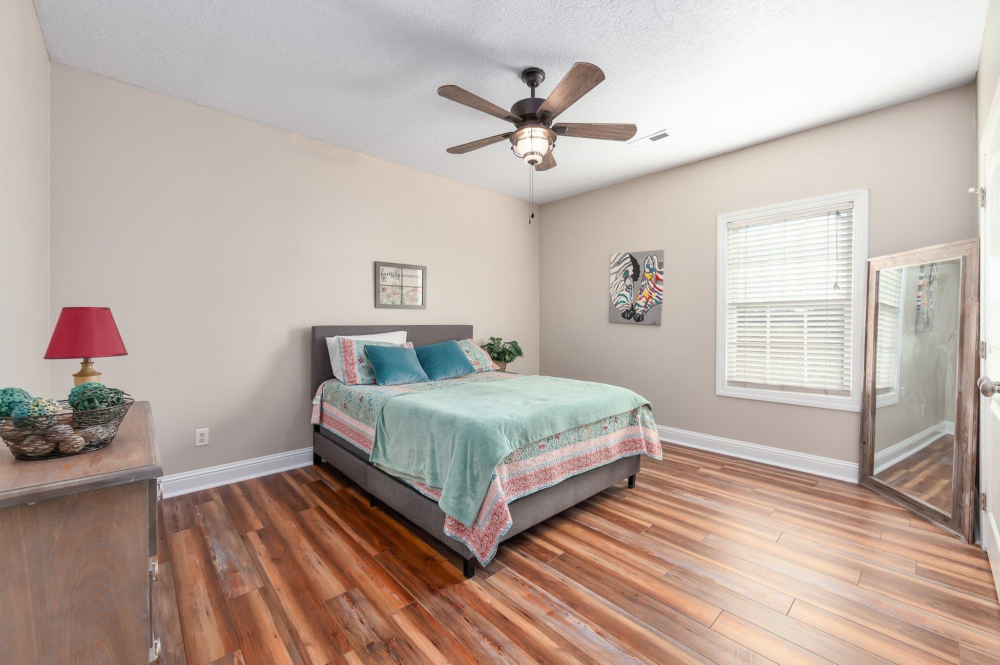 Bedroom featuring a textured ceiling, dark hardwood / wood-style floors, and ceiling fan