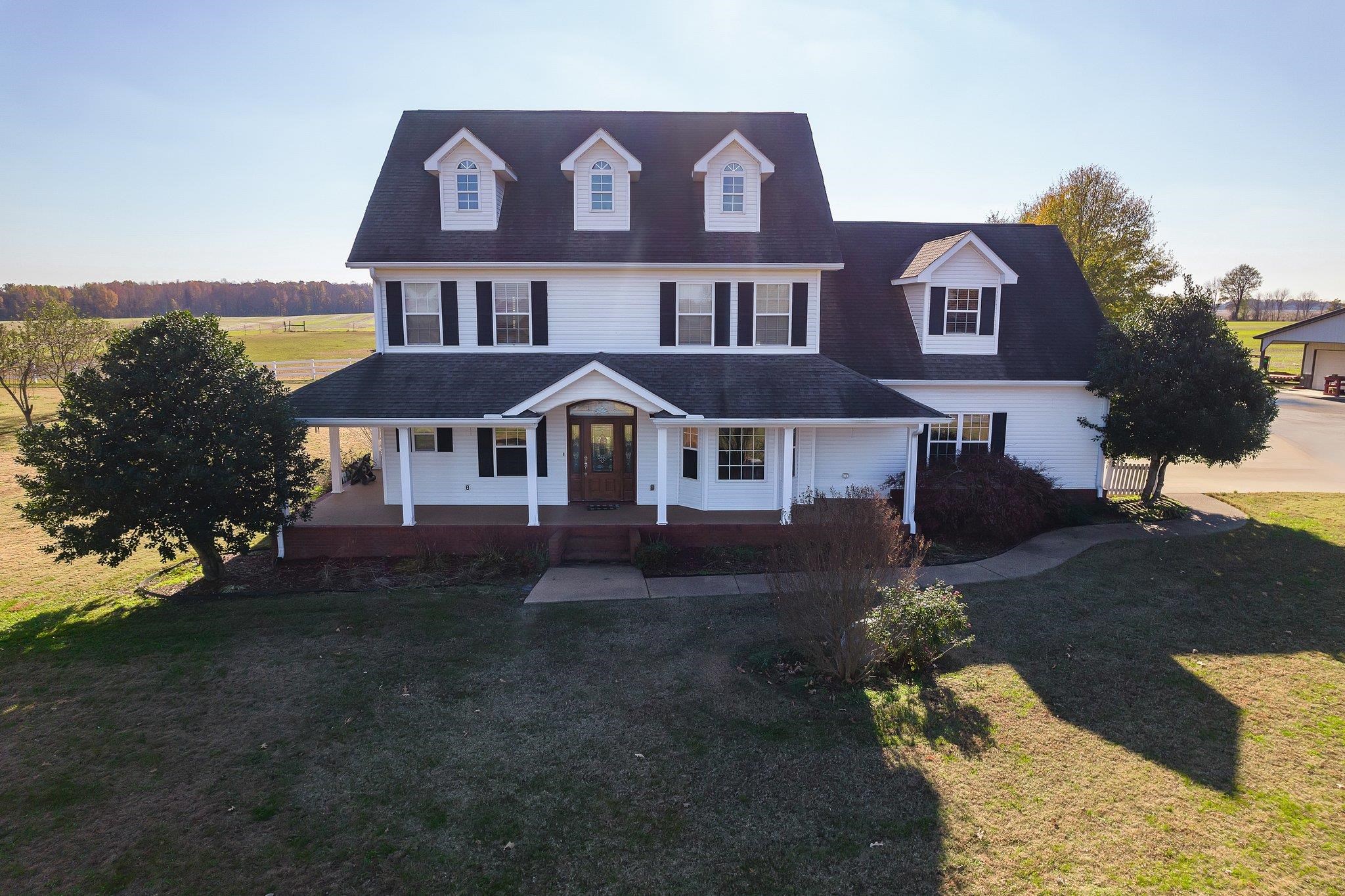 View of front facade featuring a front yard and covered porch