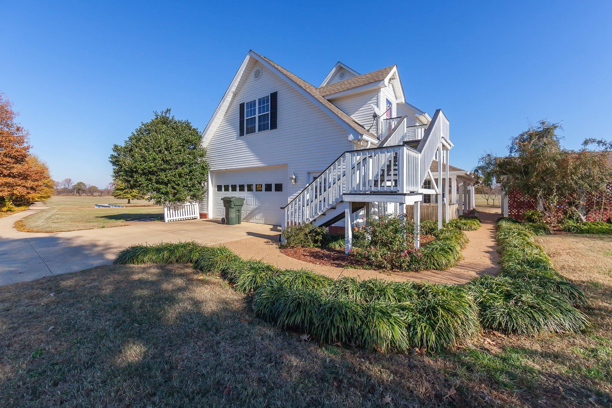 View of side of property featuring a lawn and a garage
