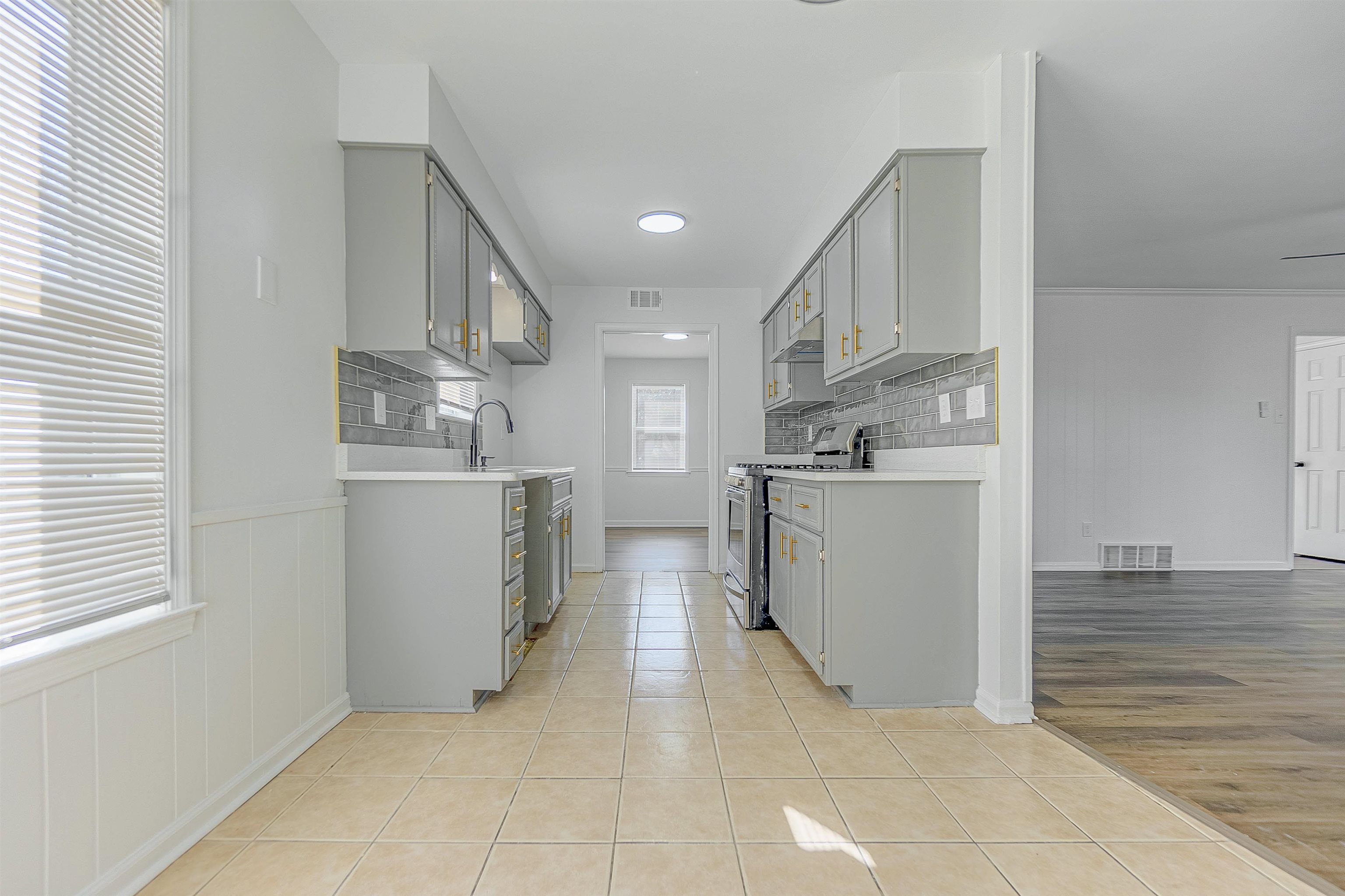 Kitchen featuring appliances with stainless steel finishes, backsplash, light hardwood / wood-style flooring, and plenty of natural light