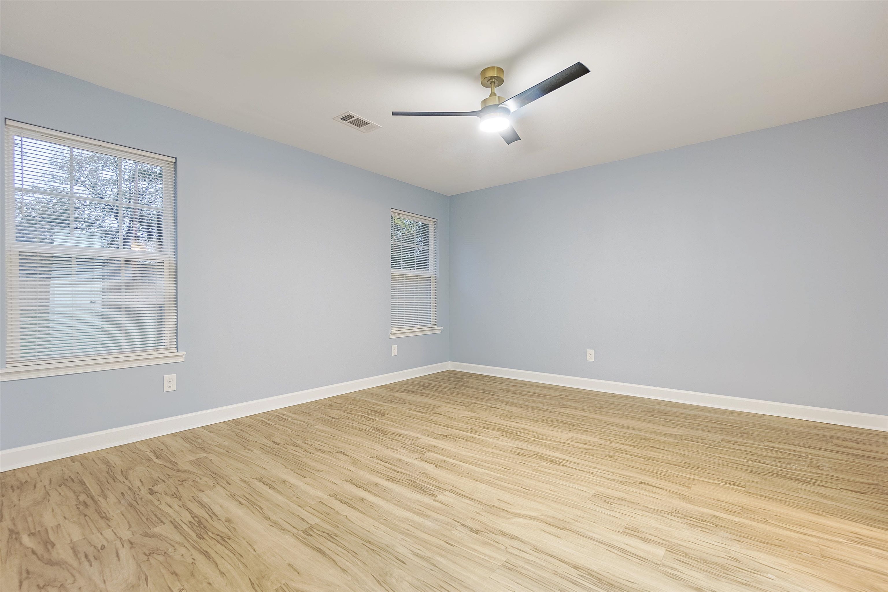 Empty room with light wood-type flooring and ceiling fan