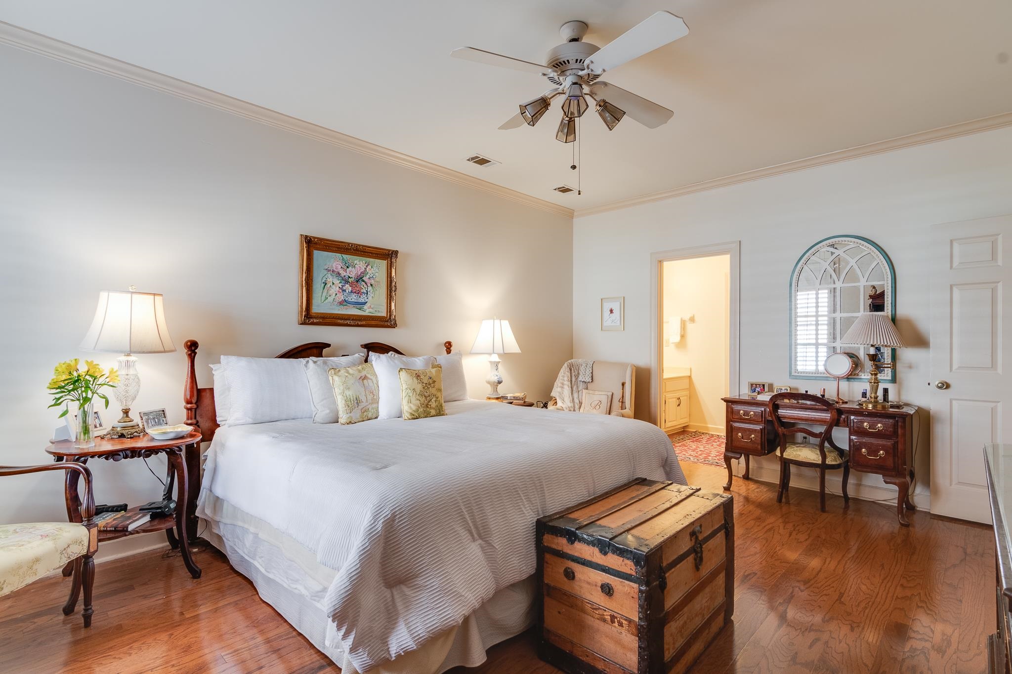 Bedroom featuring ceiling fan, dark hardwood / wood-style floors, crown molding, and ensuite bath