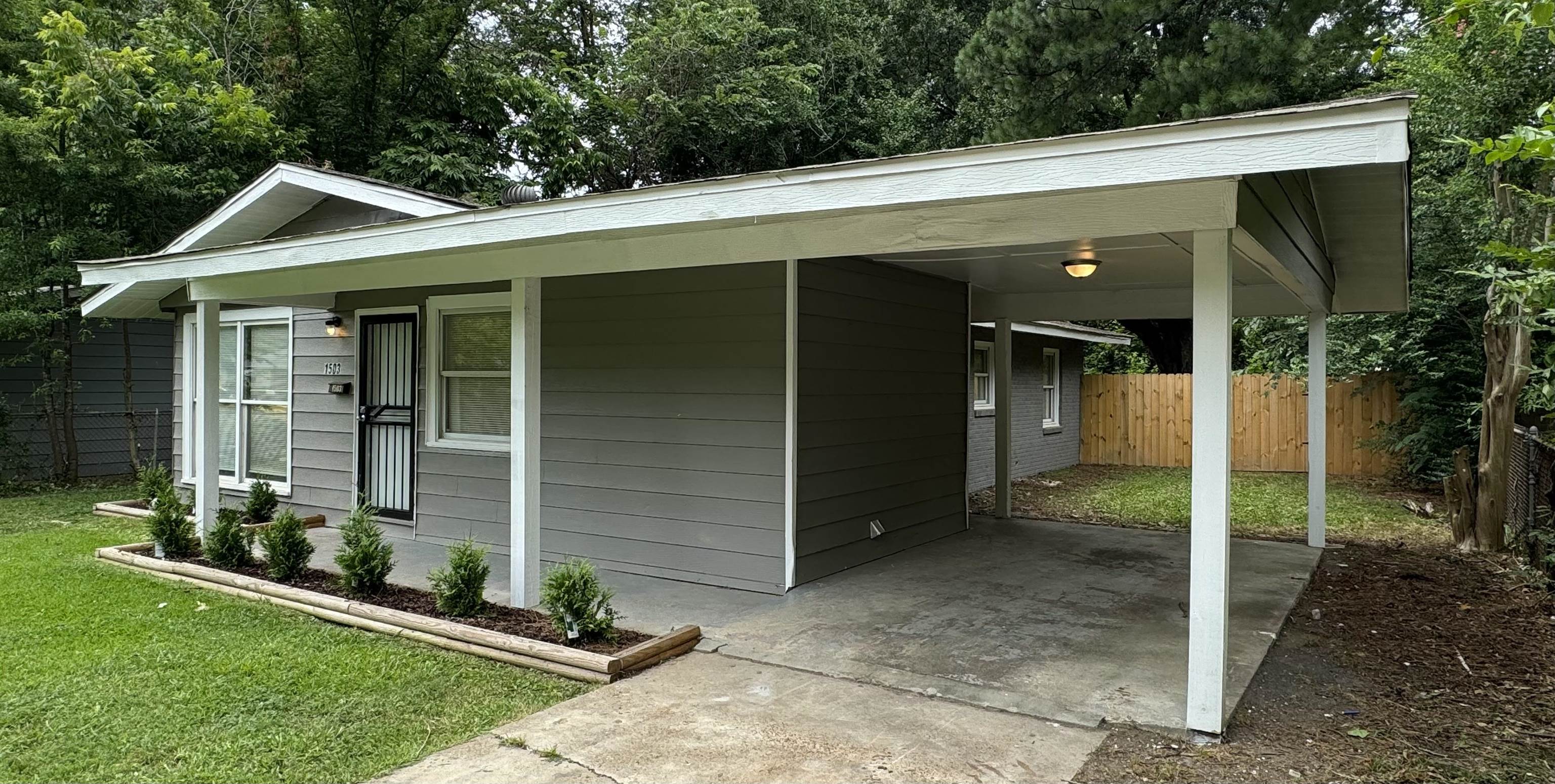 Exterior space with a lawn and a carport