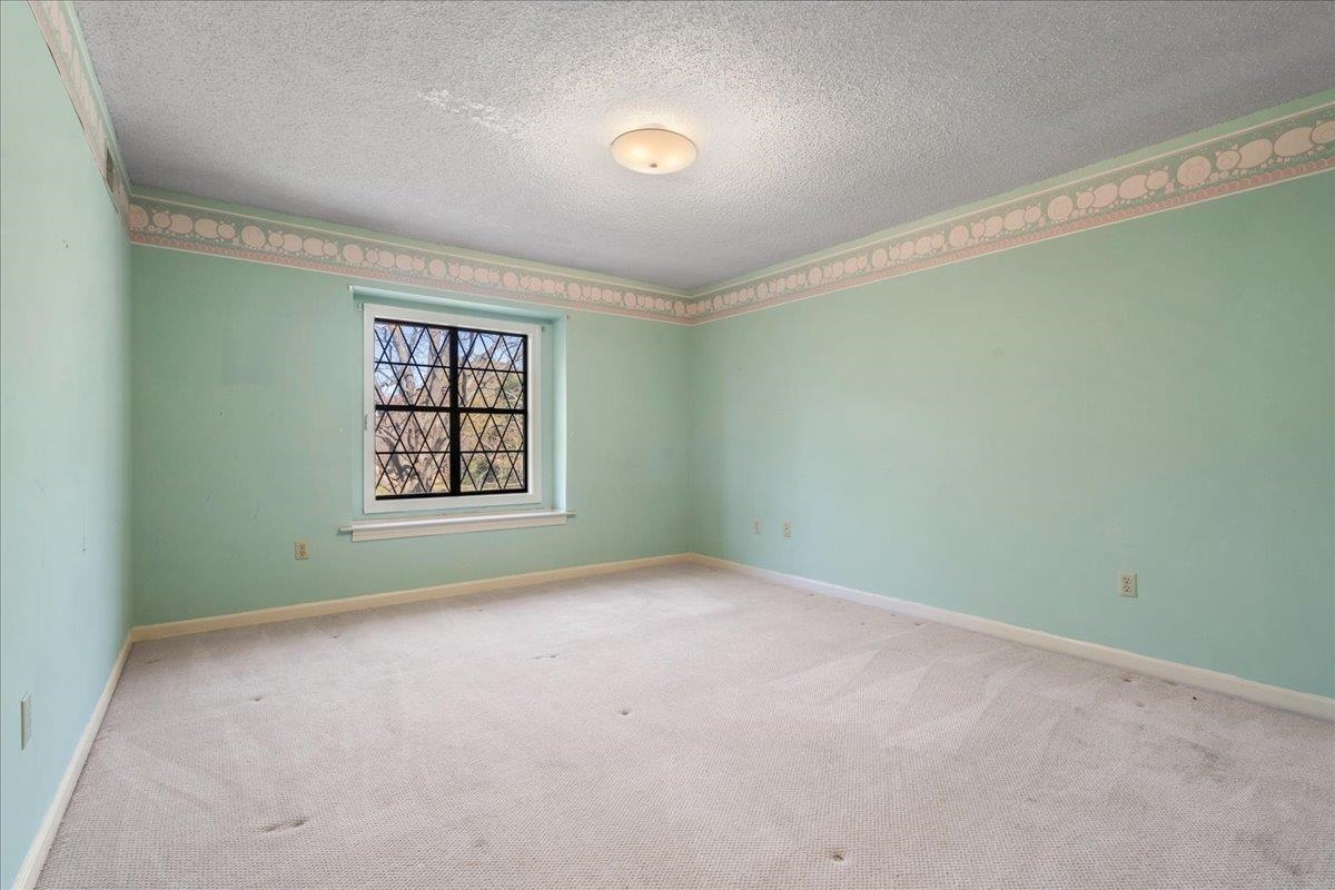 Carpeted empty room featuring a textured ceiling