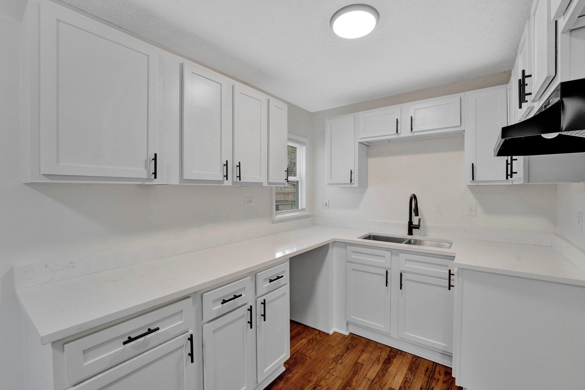 Kitchen featuring sink, white cabinets, and dark hardwood / wood-style floors