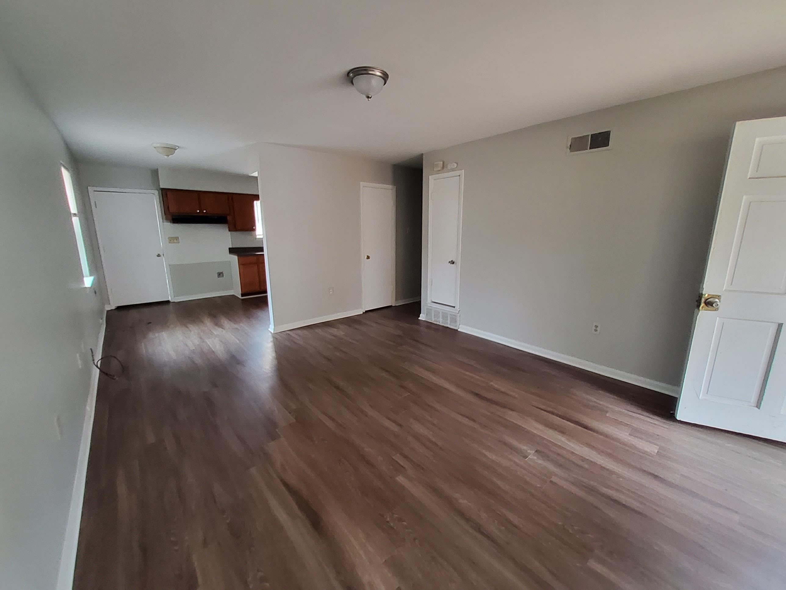 Unfurnished living room featuring dark hardwood / wood-style flooring