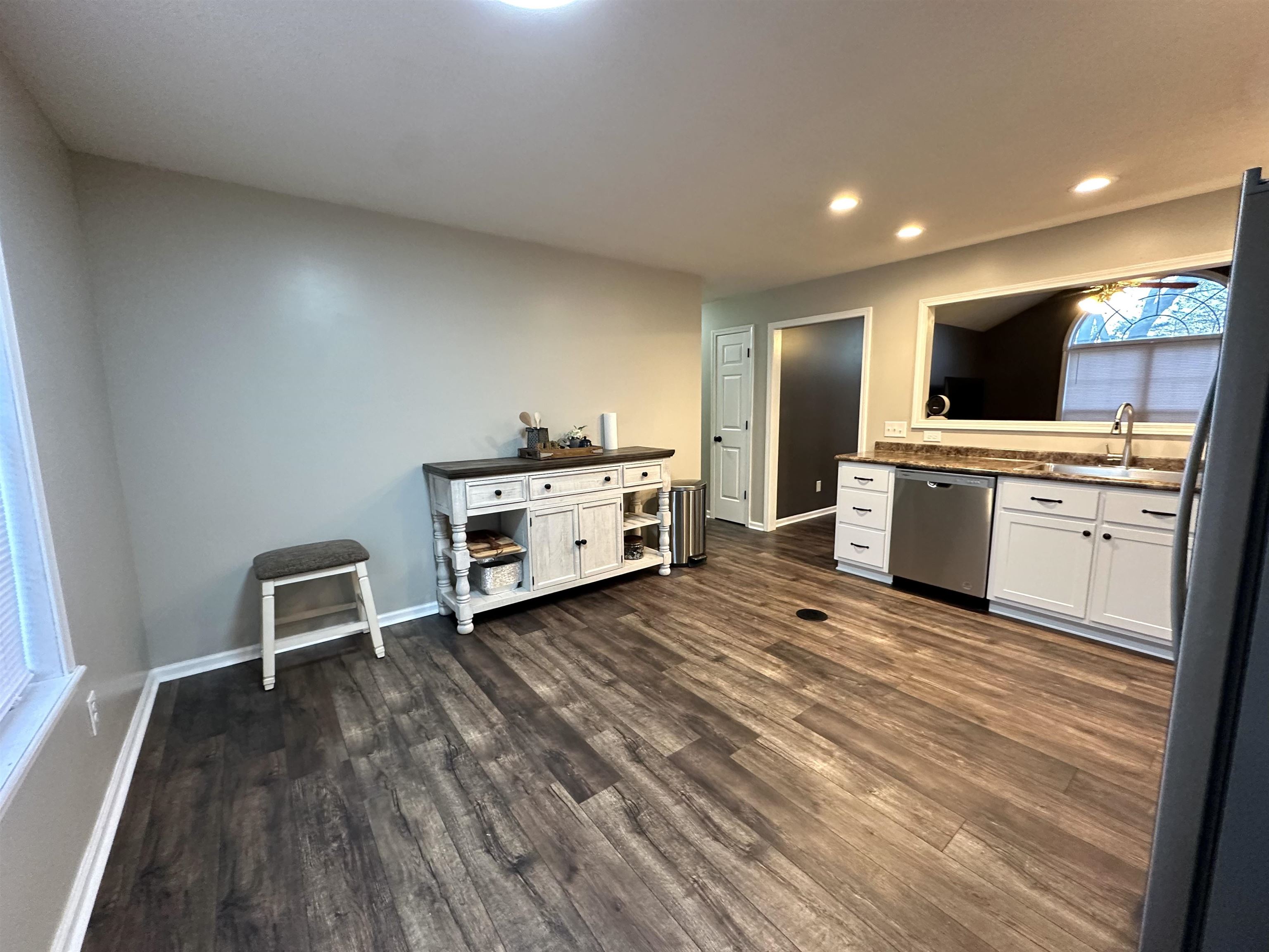 Kitchen featuring dark hardwood / wood-style flooring, white cabinets, sink, dishwasher, and fridge