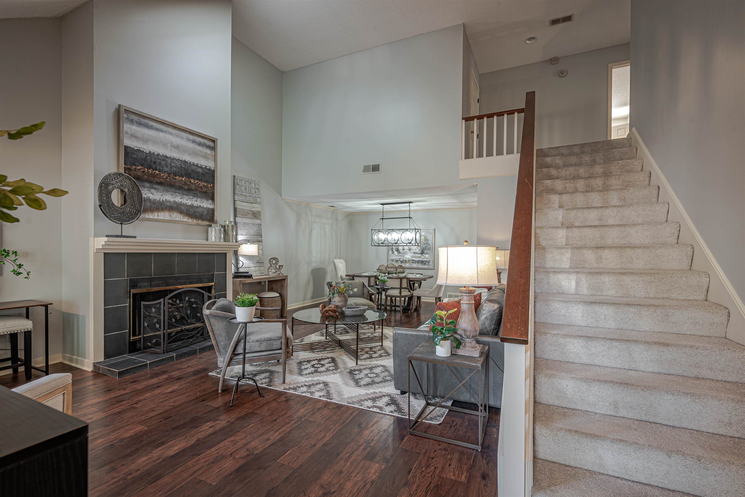 Living room featuring a fireplace, a high ceiling, and hardwood / wood-style floors