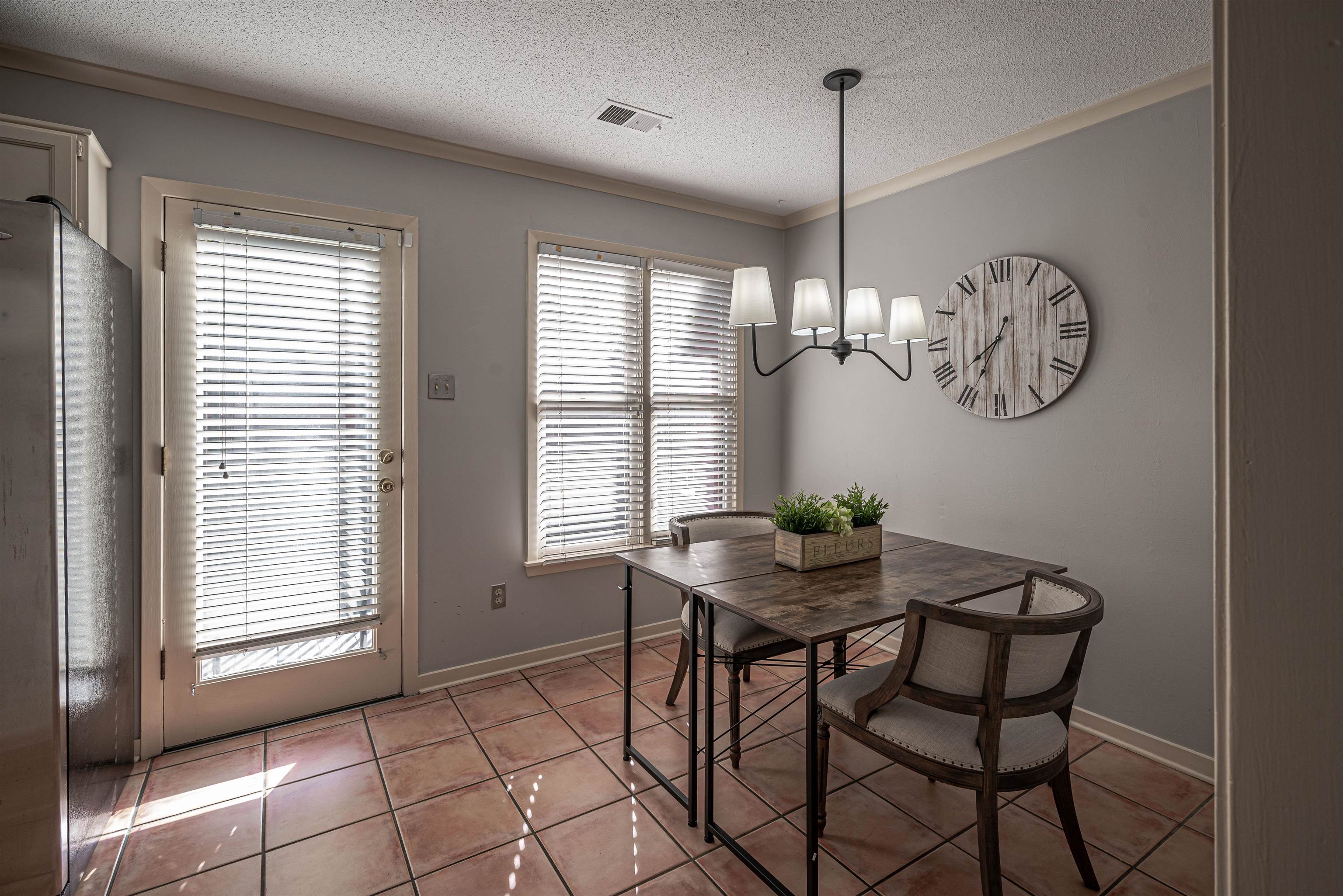 Dining space with a chandelier, a textured ceiling, a healthy amount of sunlight, and light tile patterned flooring